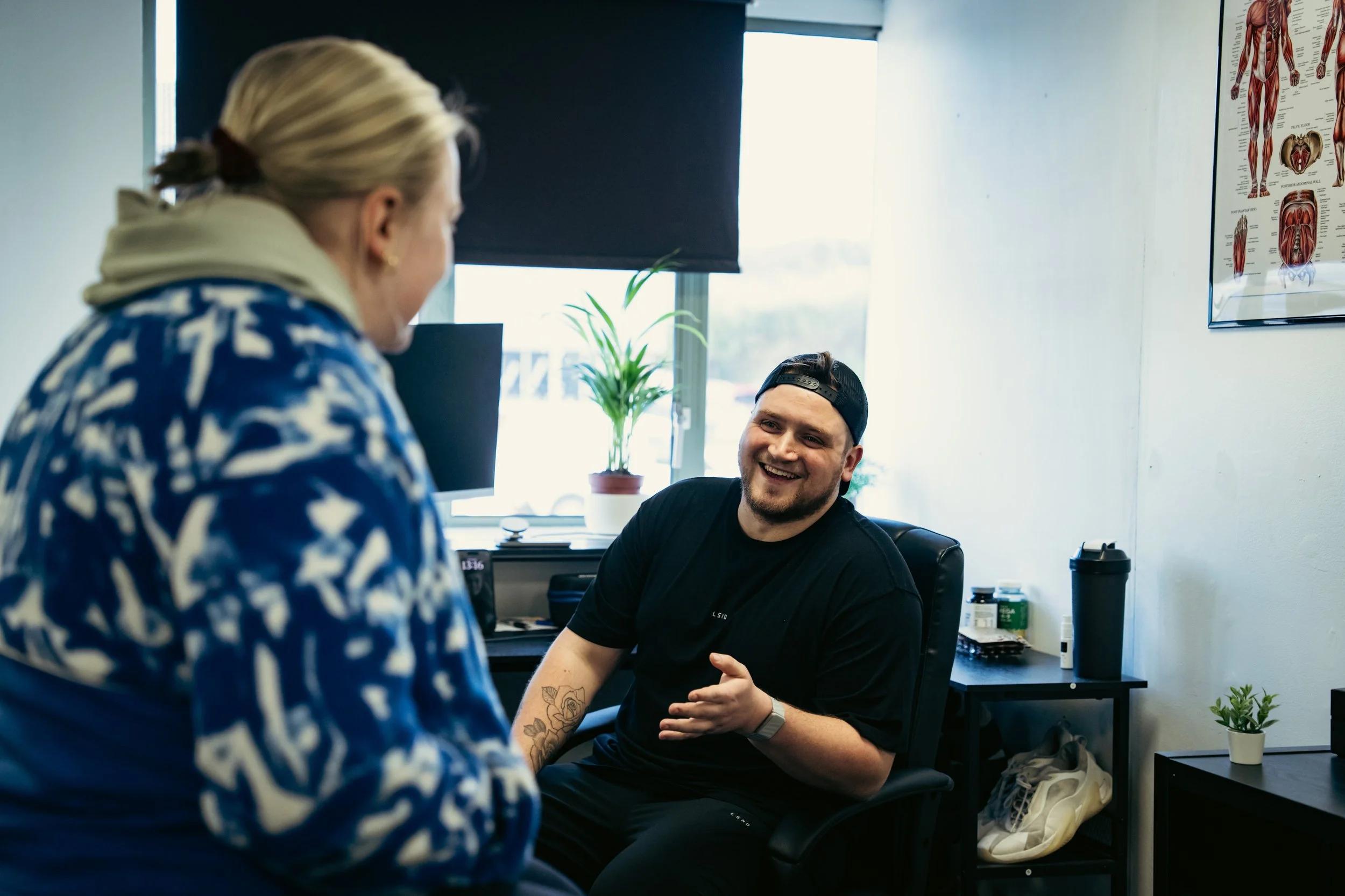 Sports therapist discussing symptoms, goals and treatment options with a client during a consultation at Training and Treatment clinic in Winchester.