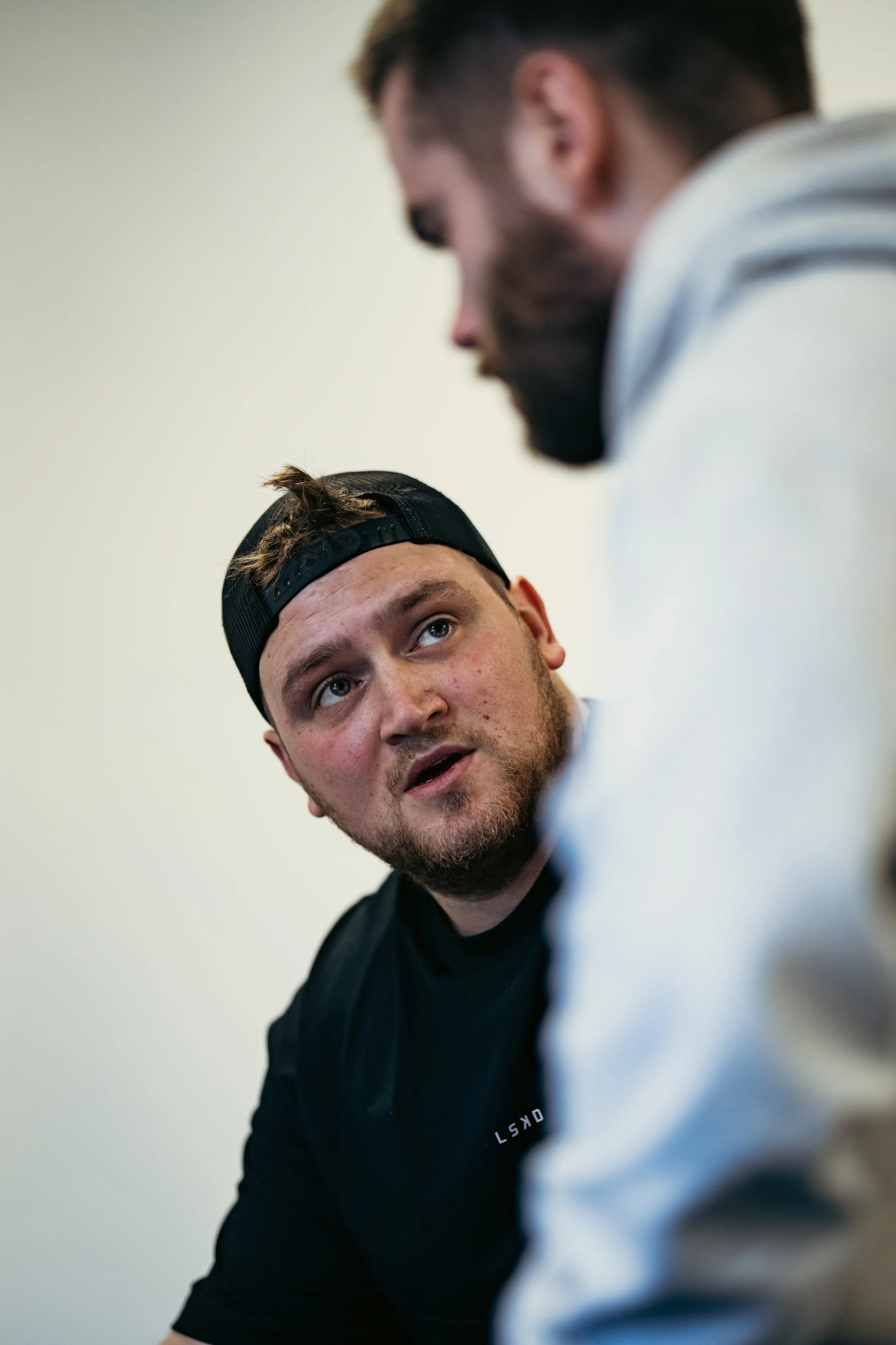 Sports therapist discussing symptoms, training demands and rehabilitation goals with a male client during a consultation at a sports therapy clinic in Winchester.