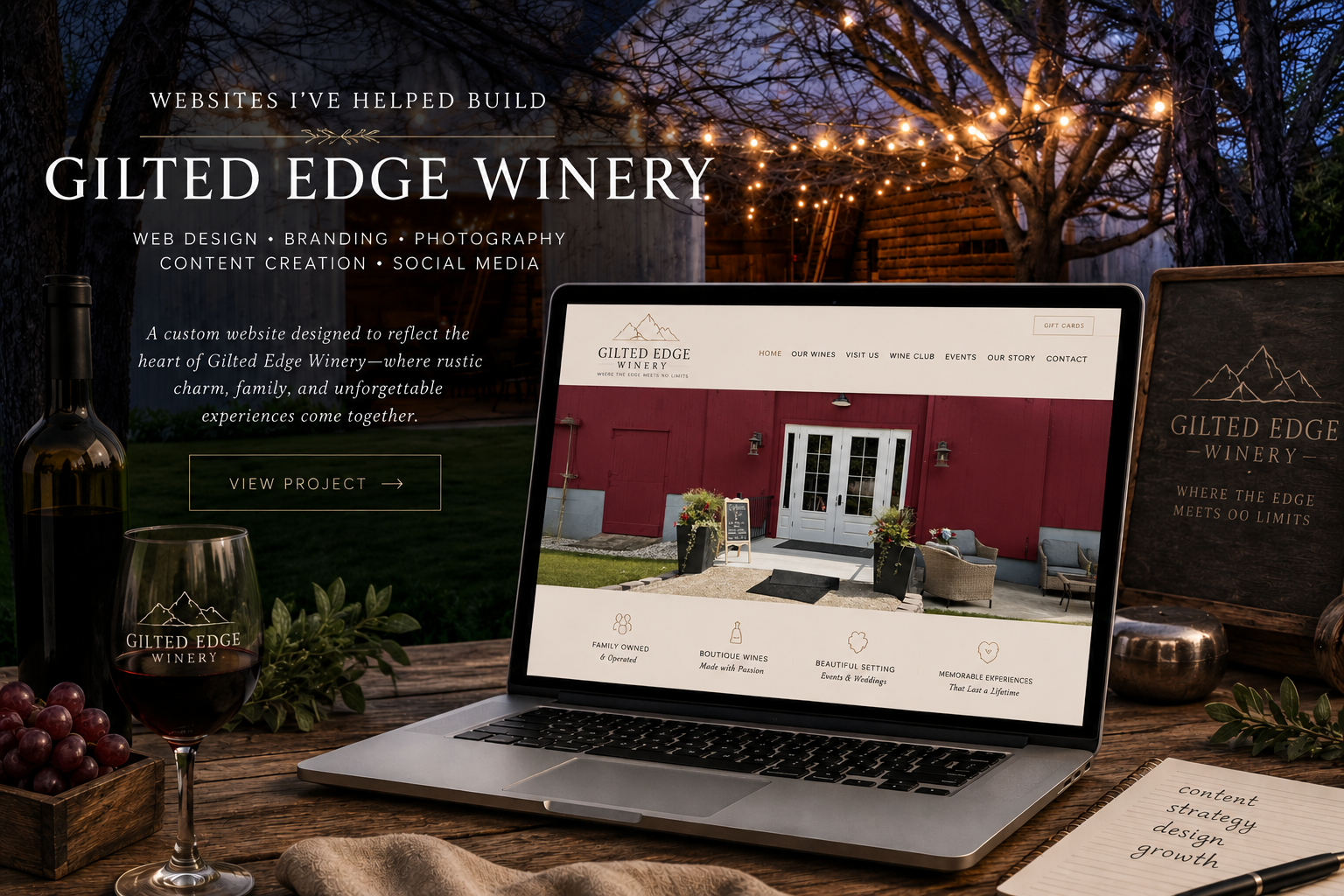 A website display of Gilted Edge Winery on a laptop, set outdoors on a rustic wooden table with a wine glass, grapes, and a notebook nearby. The scene features string lights overhead and trees in the background.