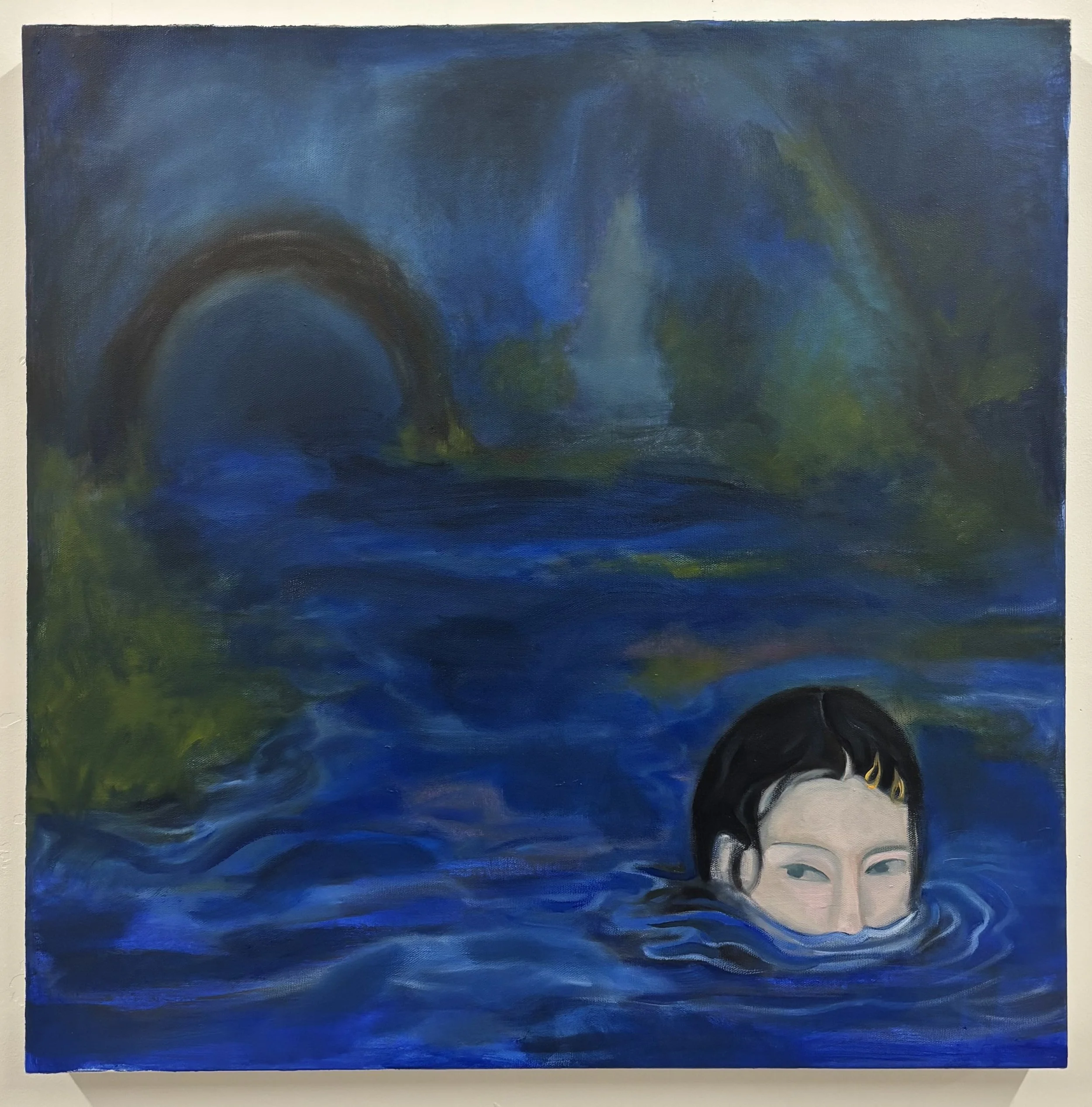 A large rectangular abstract painting predominantly in shades of blue, with some hints of green and yellow, and a partial face of a person with dark hair and blue eyes at the bottom right corner.