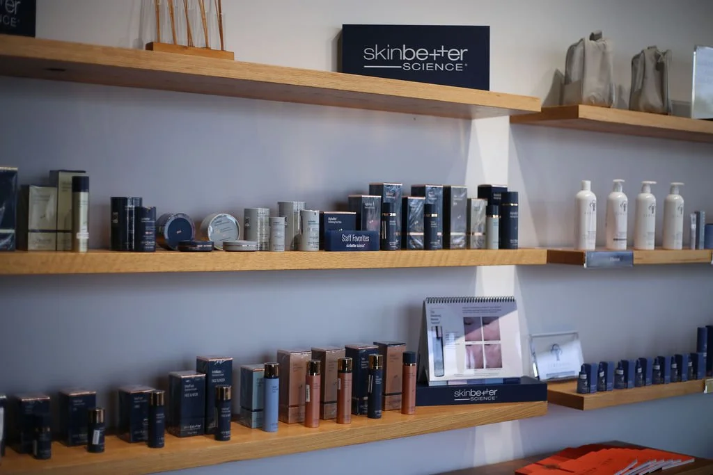 Display shelves with skincare products, including bottles and jars, arranged in front of a