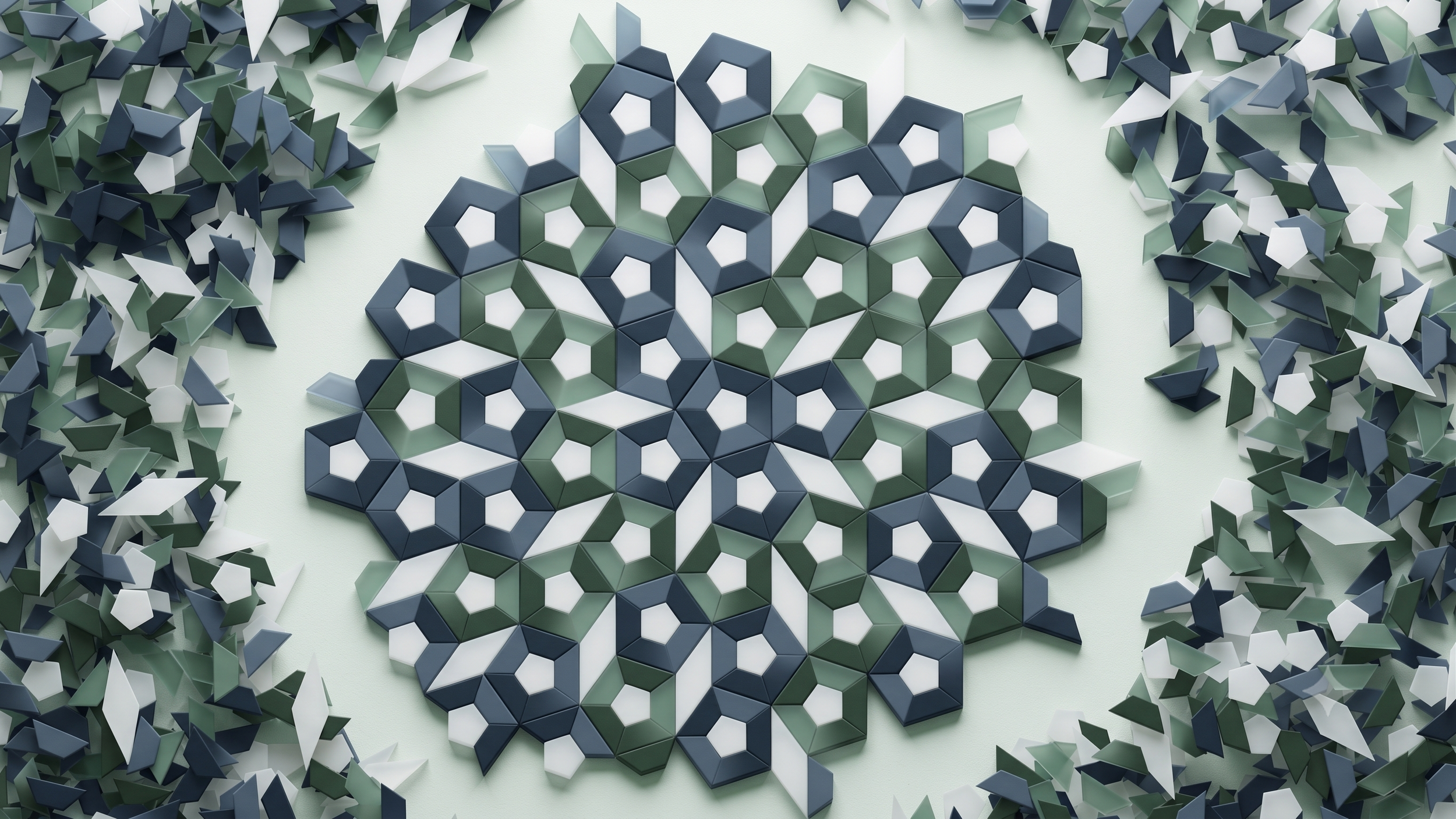 A mosaic made of small, three-dimensional tiles in shades of blue, green, white, and gray, arranged in a geometric pattern with hexagonal motifs, on a light background.