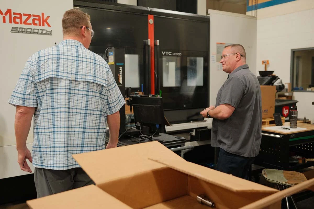 Centurion Metalworks employees working together at a Mazak CNC machine