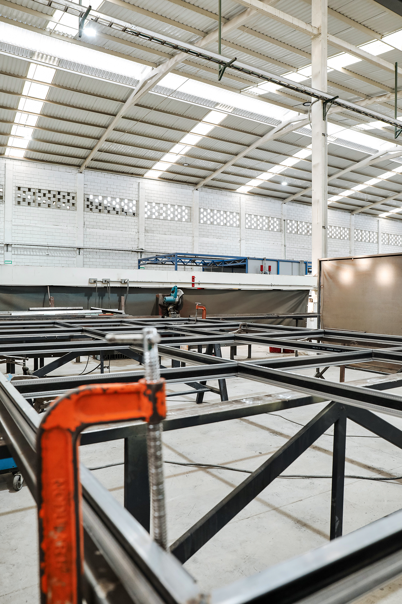 Interior of an industrial warehouse under construction with metal frames, piping, and partial walls.