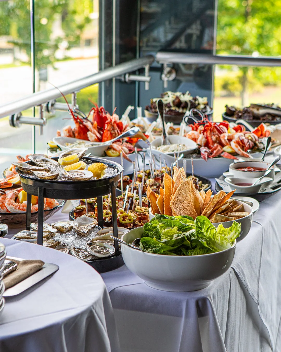 Spread of seafood, salads, chips, and condiments on a buffet table