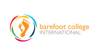 Barefoot College International logo featuring a colorful circular design with a barefoot foot and the text 'barefoot college INTERNATIONAL'.