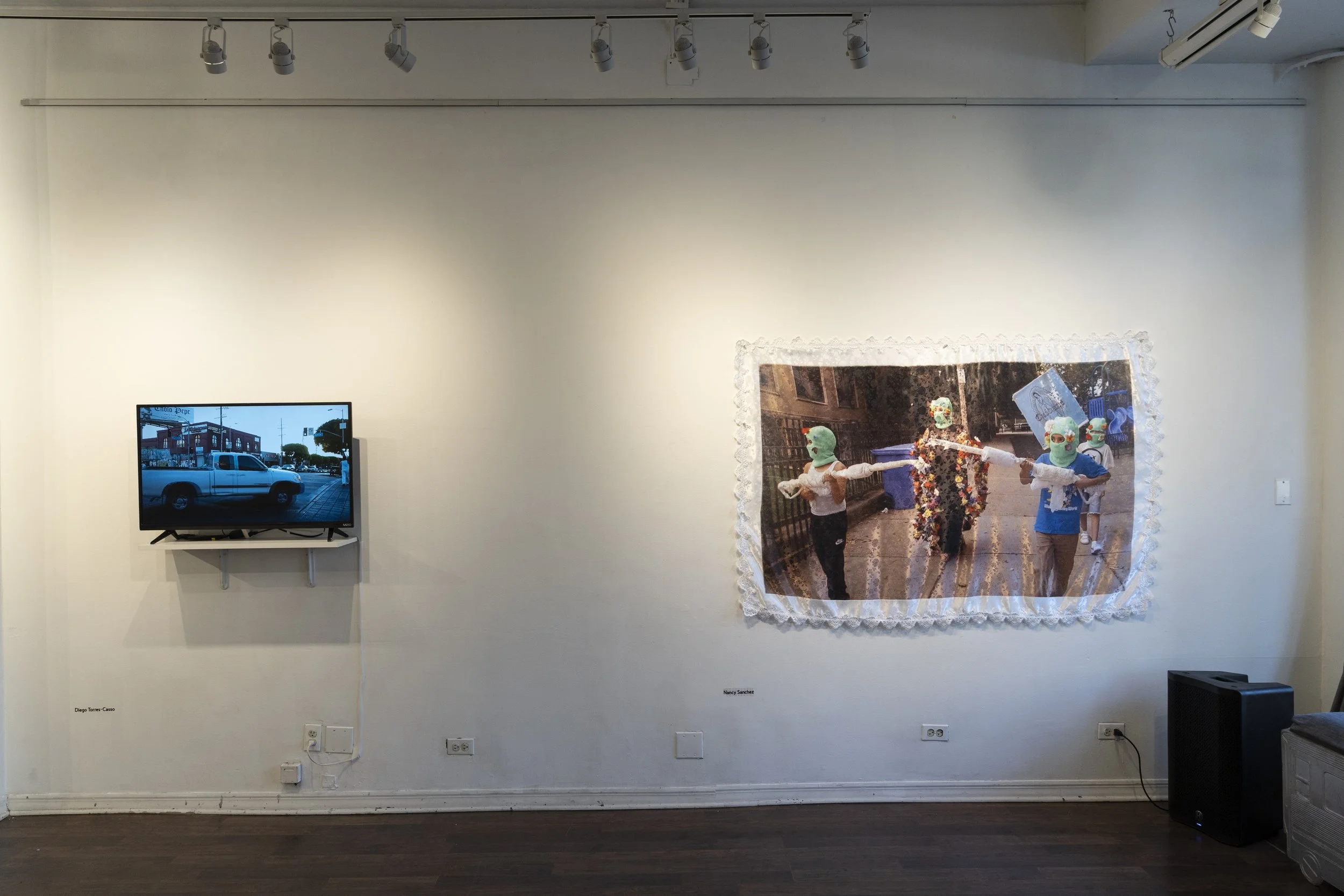  On the Left: Video Installation in  ASCO: A Study Call to Response - Acts of Protest from L.A. to Chicago , at Pilsen Arts and Community House. Chicago, IL.  Piece on the right by artist Nancy David Sánchez Tamayo Photo credit Kyle Flubacker 