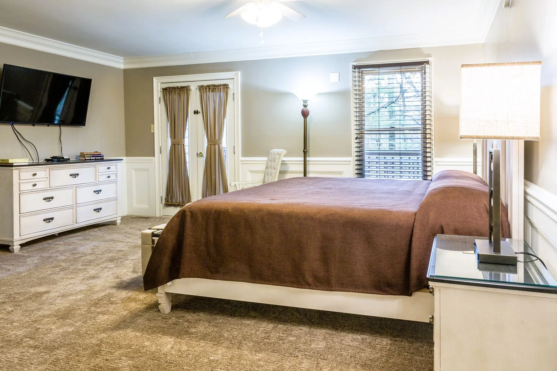 Main floor master bedroom with a king bed and flat screen TV inside a bi-level suite.