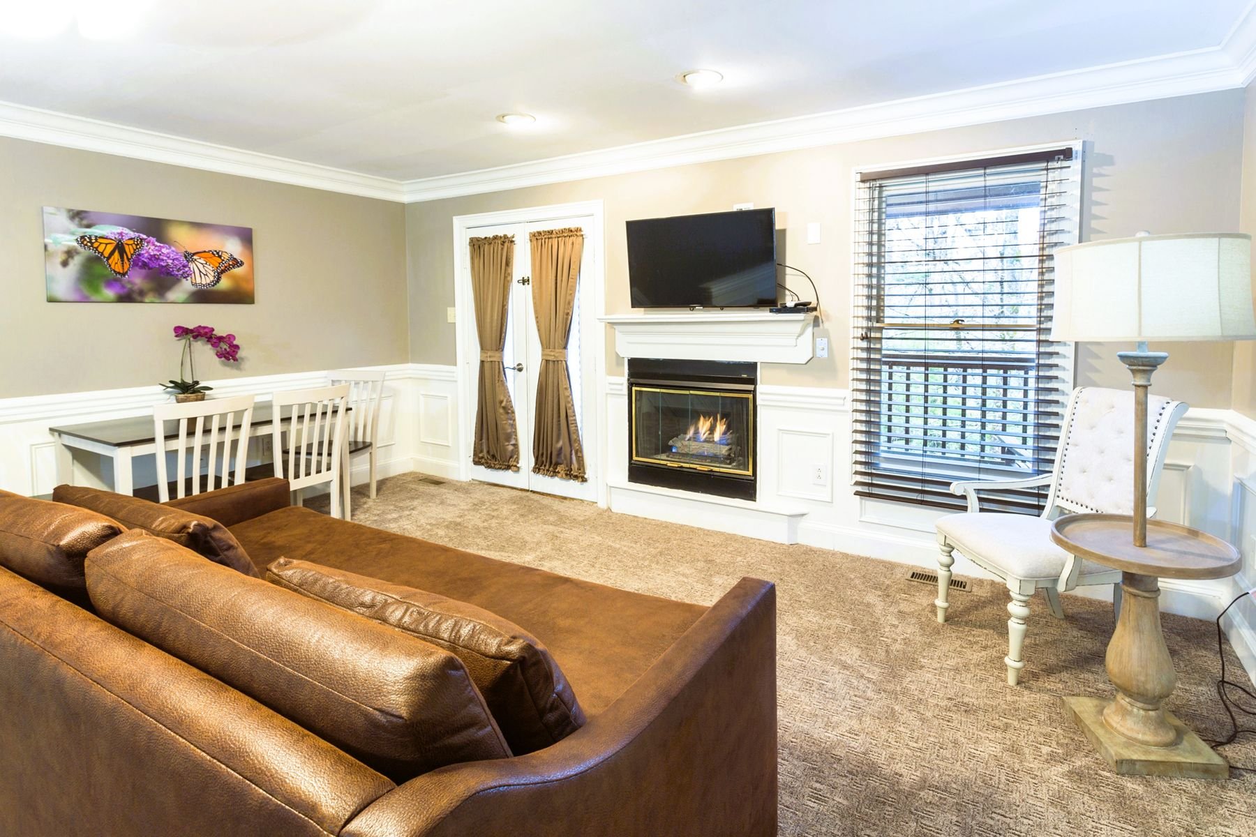 Second floor open floor plan loft with a gas fireplace, twin daybed, and kitchenette.