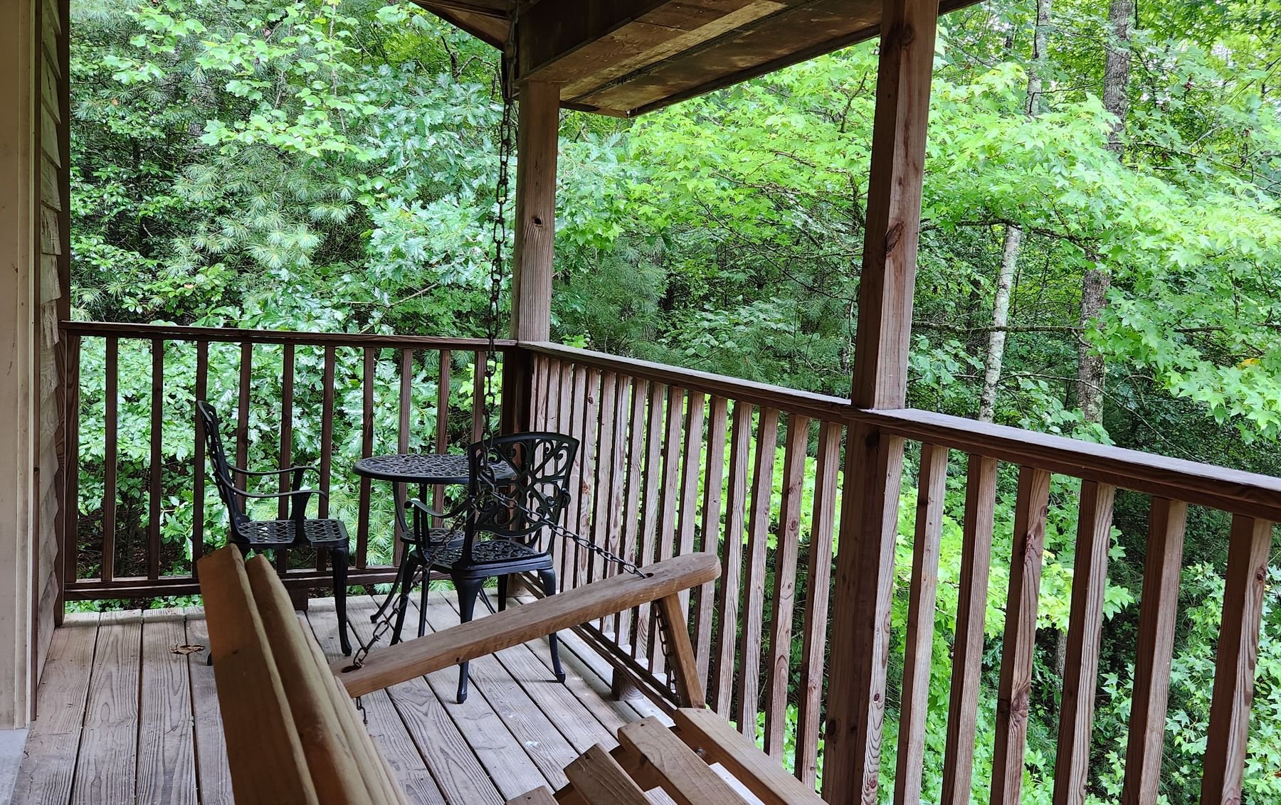 Private wooden balcony overlooking a quiet wooded forest area outside a romantic Wilderness Lodge suite