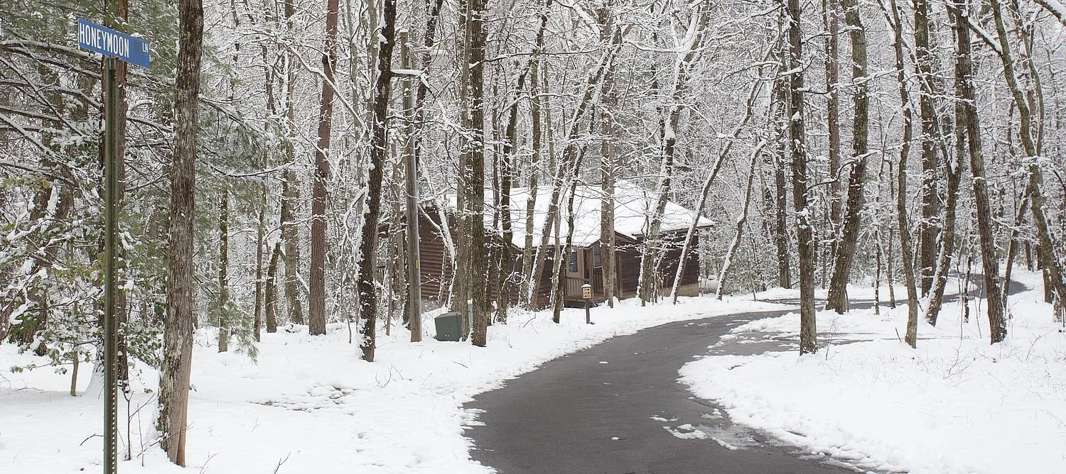 Honeymoon Lane street sign & cabin in the snow at Forrest Hills Resort