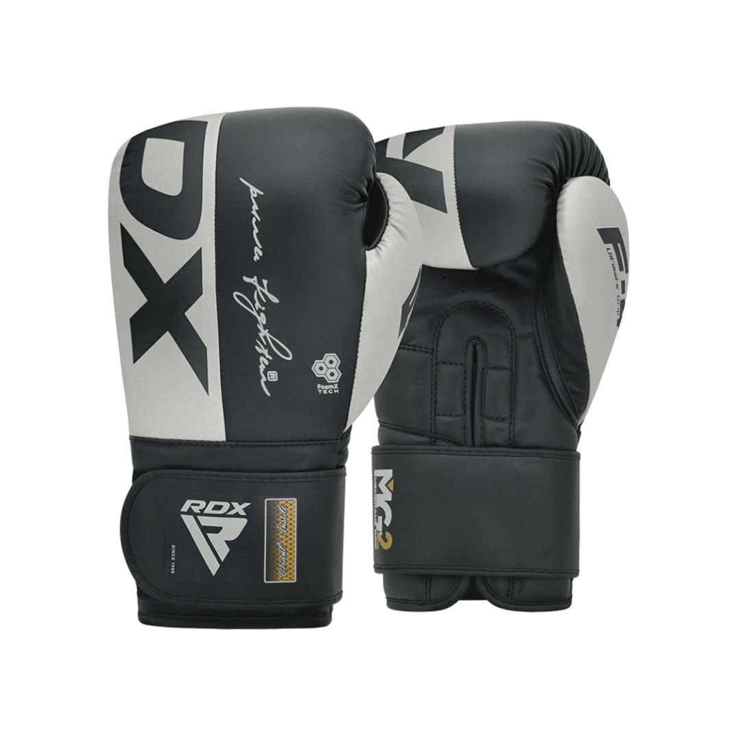 Pair of black and white boxing gloves with branding and signatures.