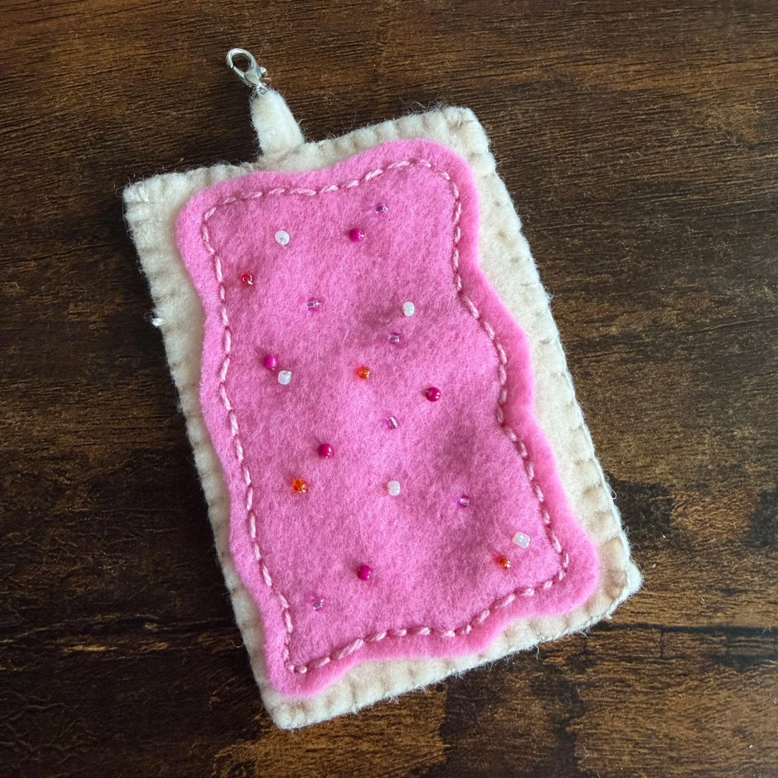 A small felt keychain created to look like a Strawberry Pop Tart