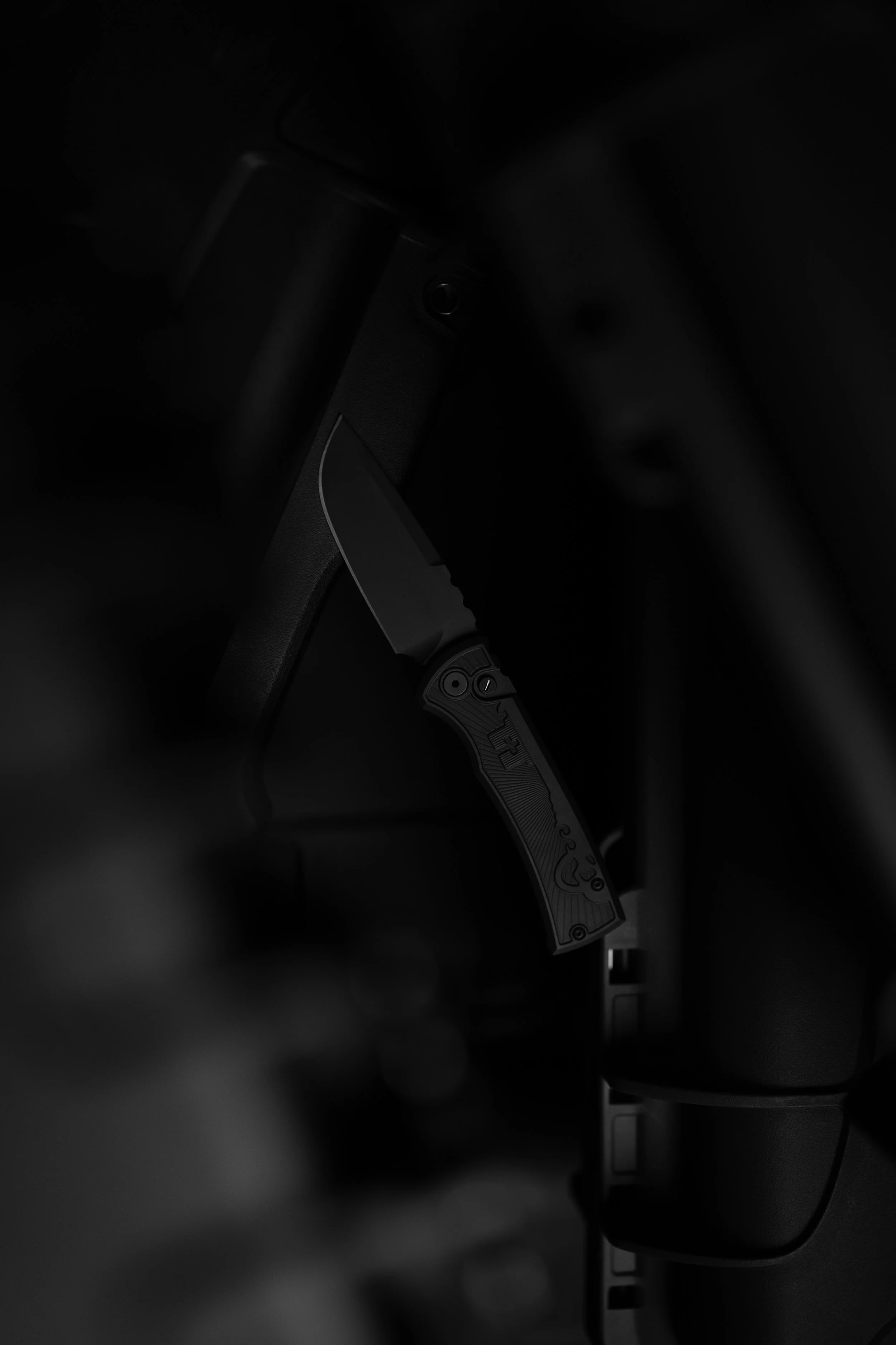 A black handgun resting on a dark surface, with part of its grip and trigger visible.