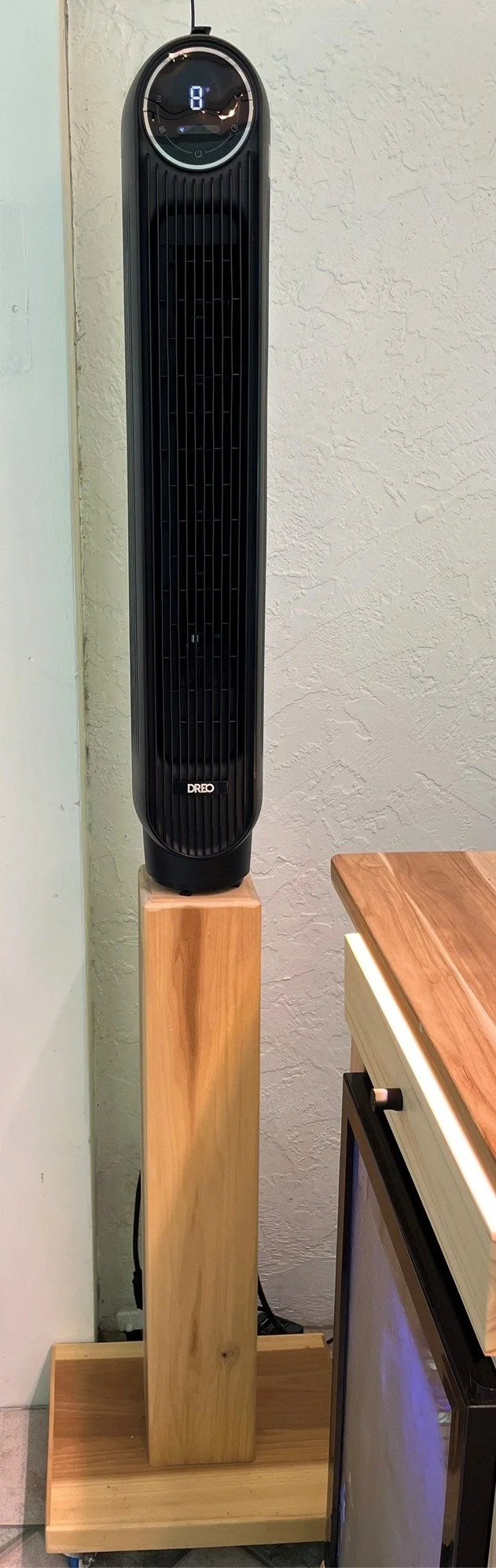 A tower fan on a rolling base to keep the chef cool