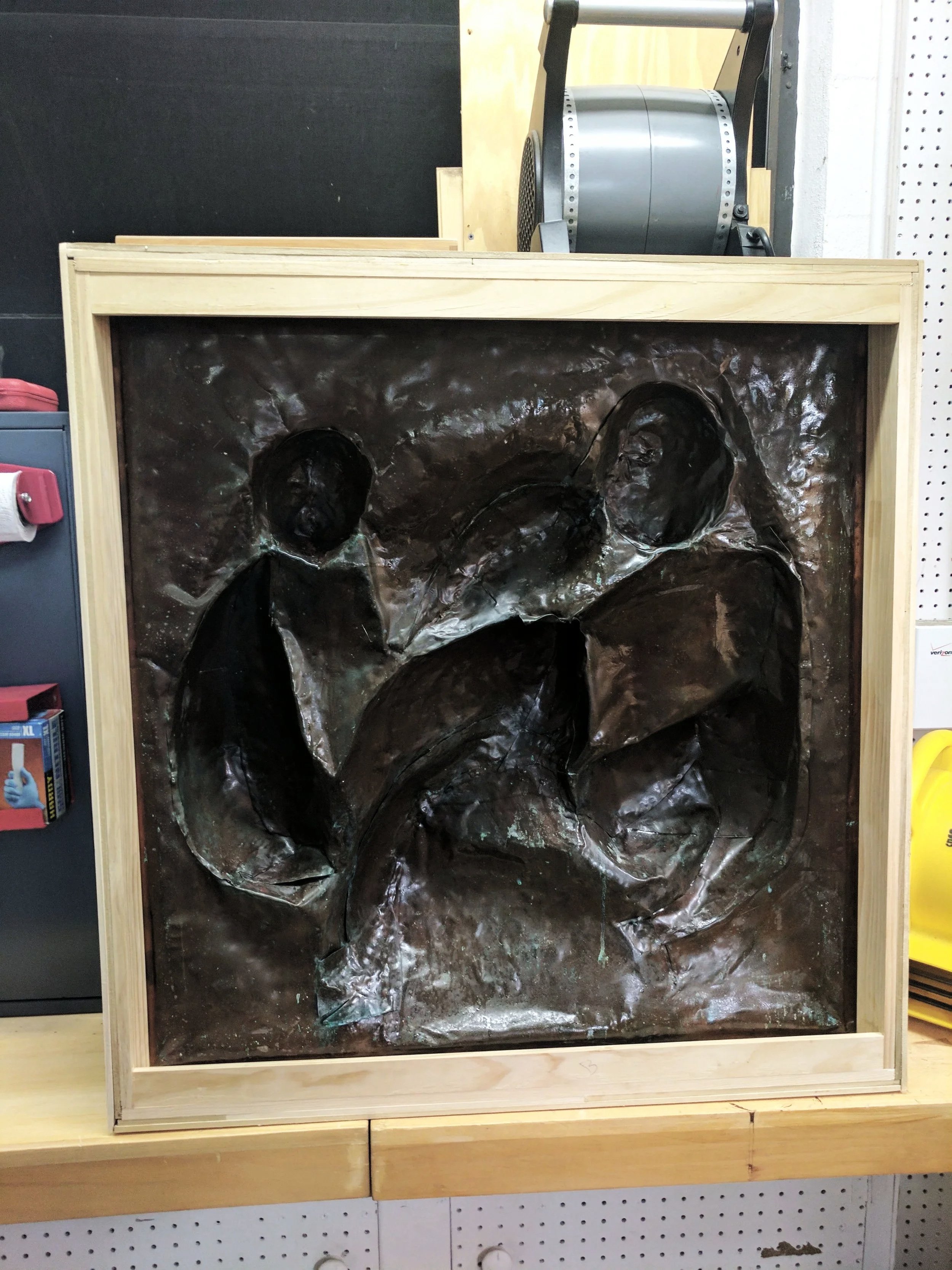 The Family sculpture during restoration and framing