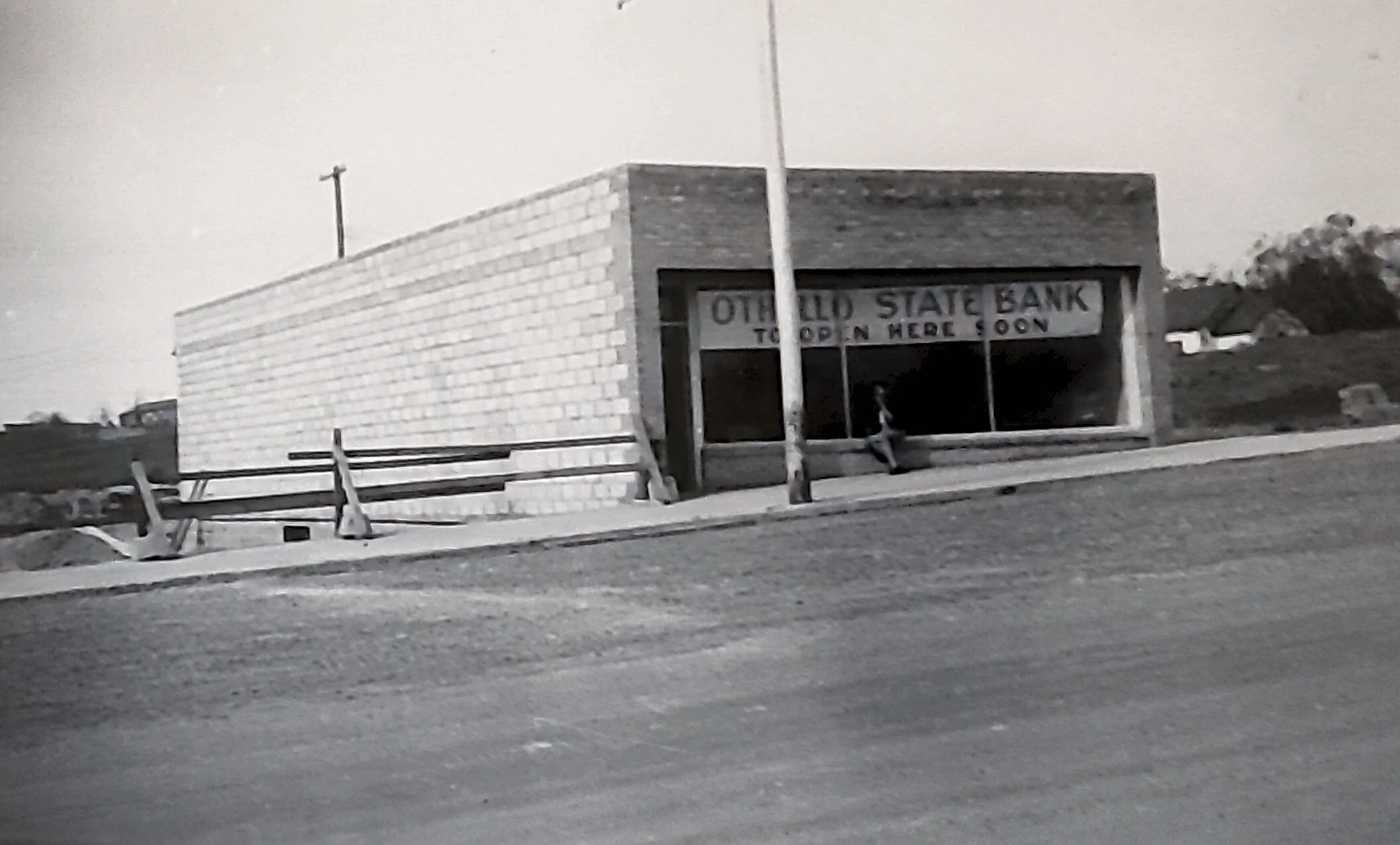 Old State Bank building with a sign that says 'TO OPEN HERE SOON', suggesting it is under renovation or construction.