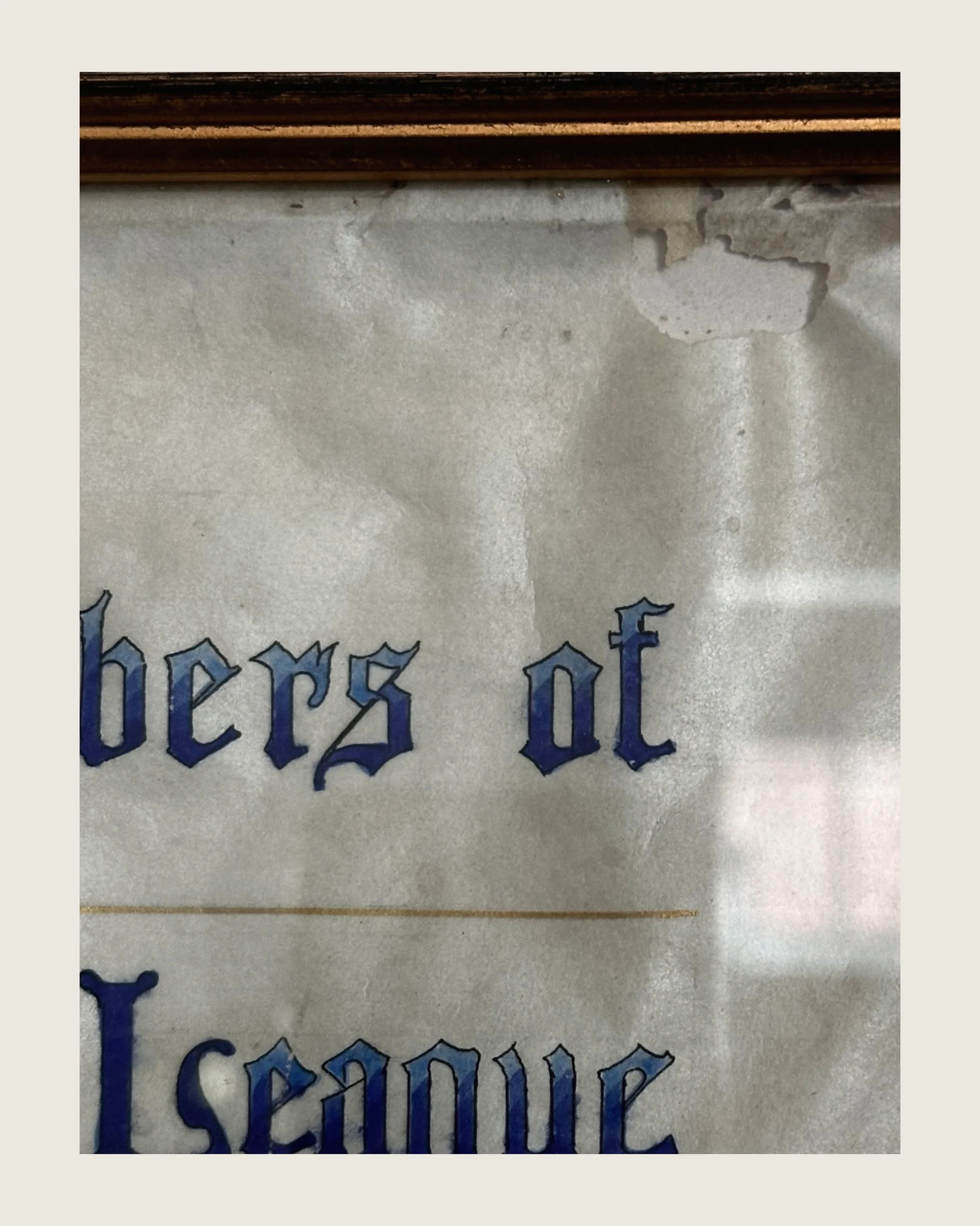 Detail of the framed 1915 Ellin Prince Speyer testimonial showing visible age-related rippling, staining, small tears, and discoloration.