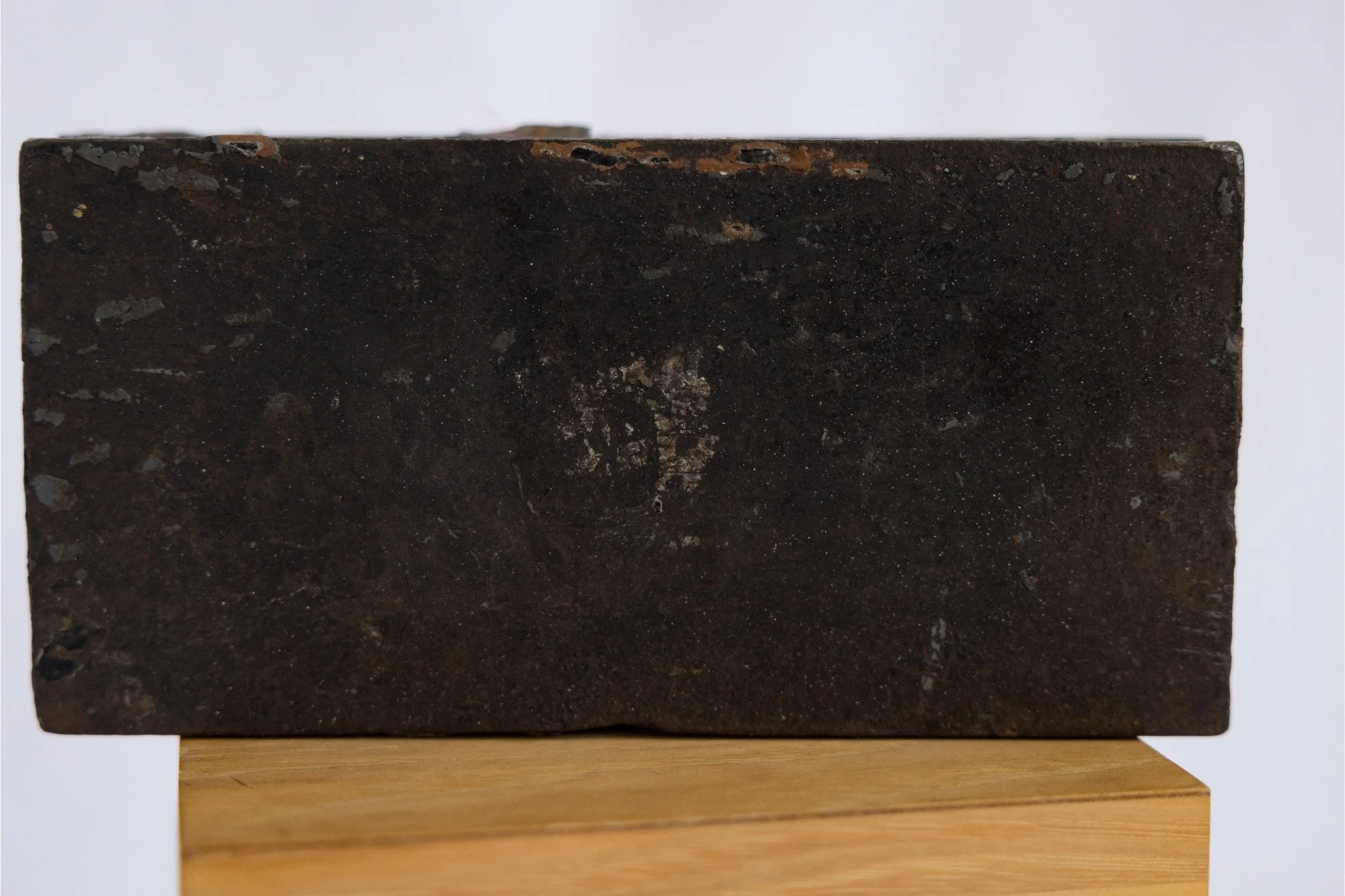 Reverse or interior detail of the No. 9 identification clamp showing its dark metal surface.