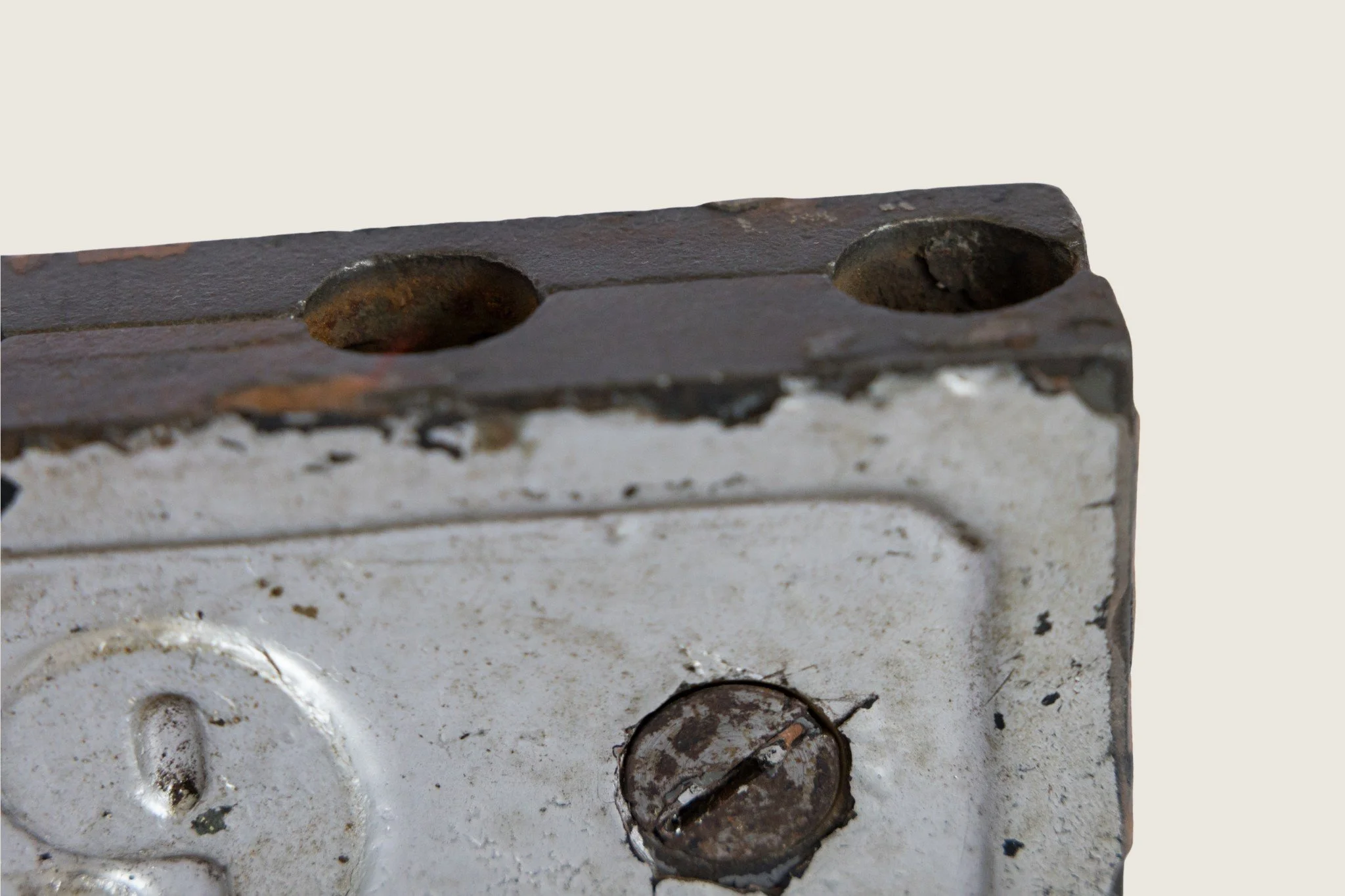 Close detail of the raised numeral 9 and slotted screw heads on the identification clamp.
