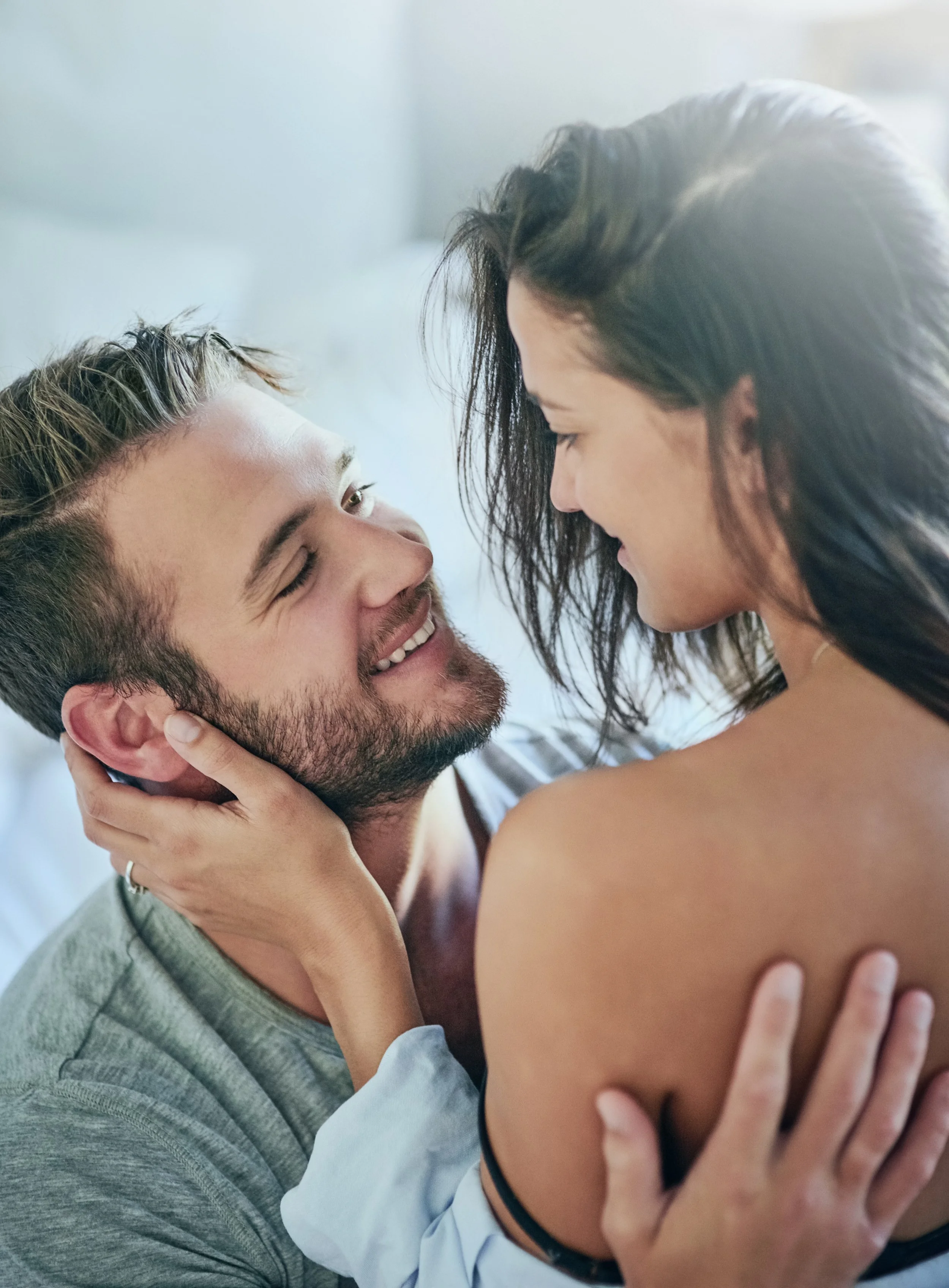 A man and a woman looking into each others' eyes longingly