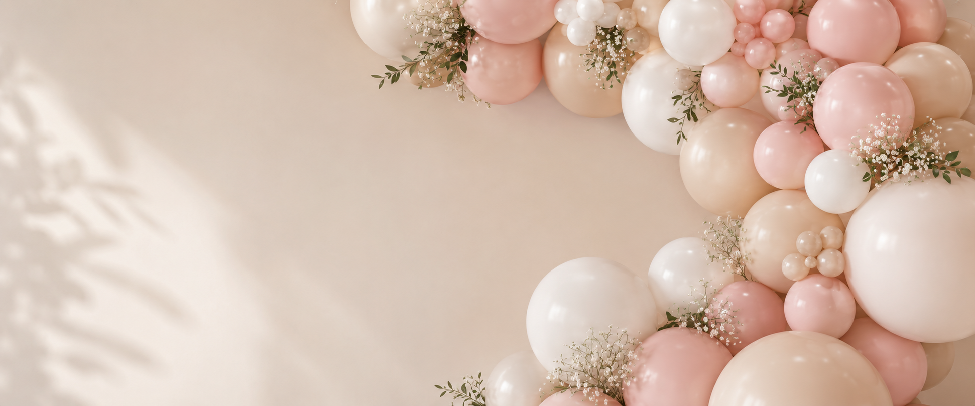 A decorative arrangement of pink, white, and cream-colored balloons accompanied by small white flowers and green leaves on a beige background.