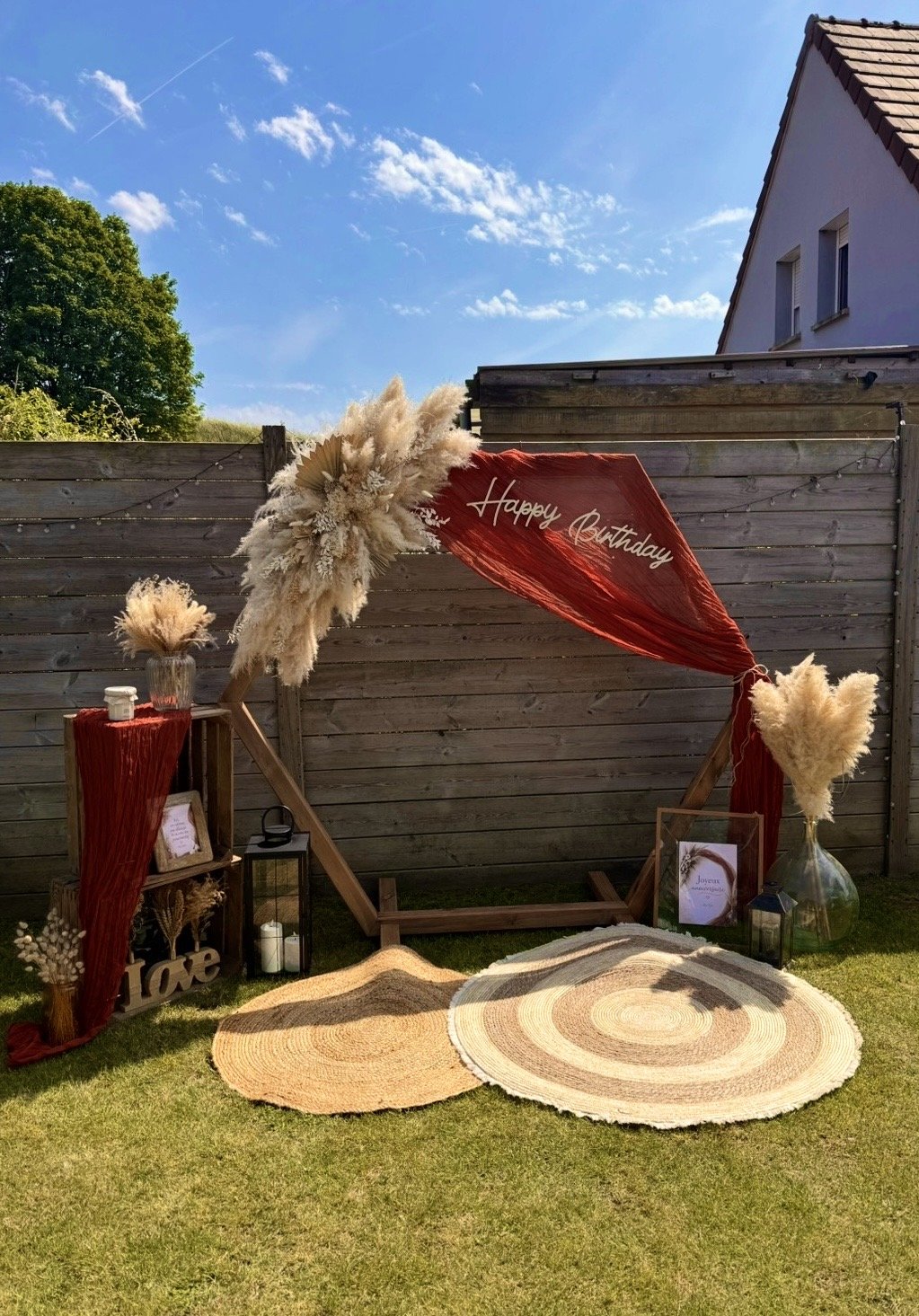 Décoration d’anniversaire avec panneau Happy Birthday, tapis en jute, vases et fleurs séchées, disponible à la location sur la Côte d’Opale.