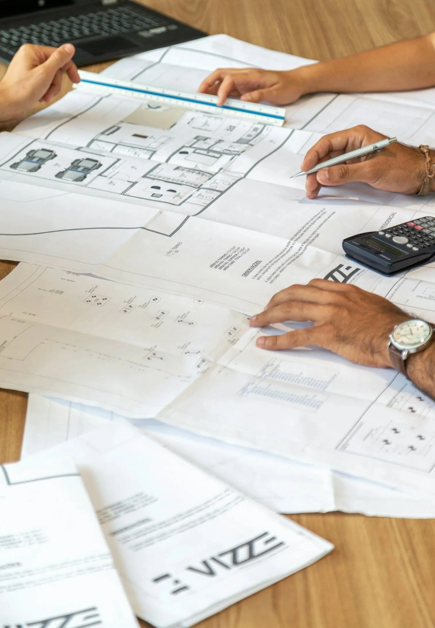 Photo of people working together while looking at construction drawings