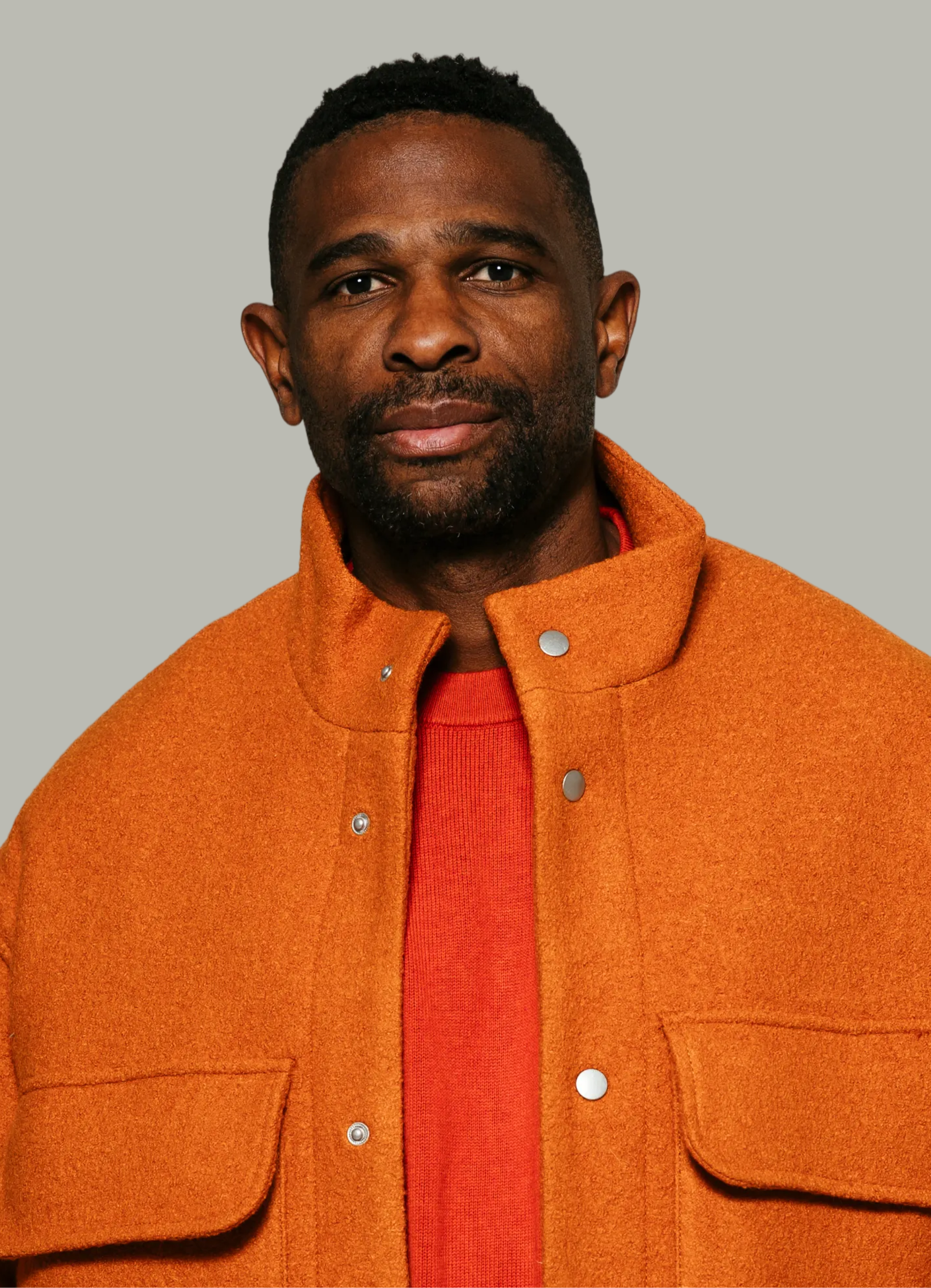 Portrait of a male tutor in an orange jacket and shirt
