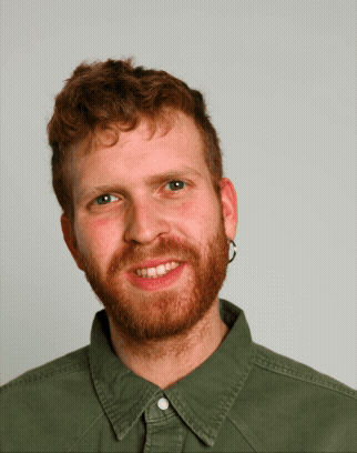 A portrait GIF of a male student in a green shirt laughing and smiling