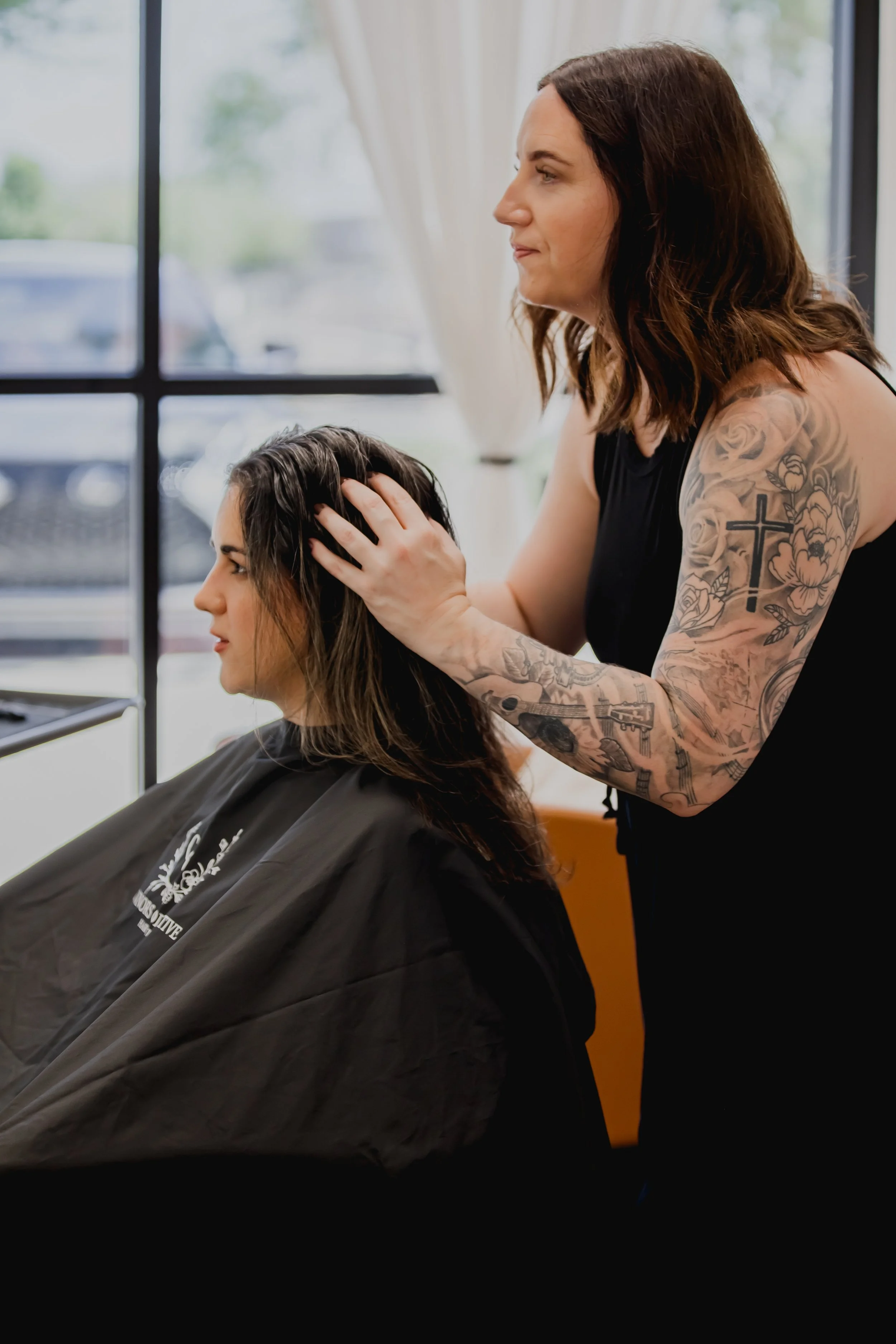 hair loss specialist Sara Connors is touching her clients hair and talking about what will work best for her hair texture in her private studio setting.