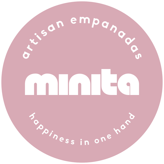 A pink circular logo with white text that reads "artisanal empanadas" at the top and "happiness in one hand" at the bottom, with the word "minta" in bold in the center.