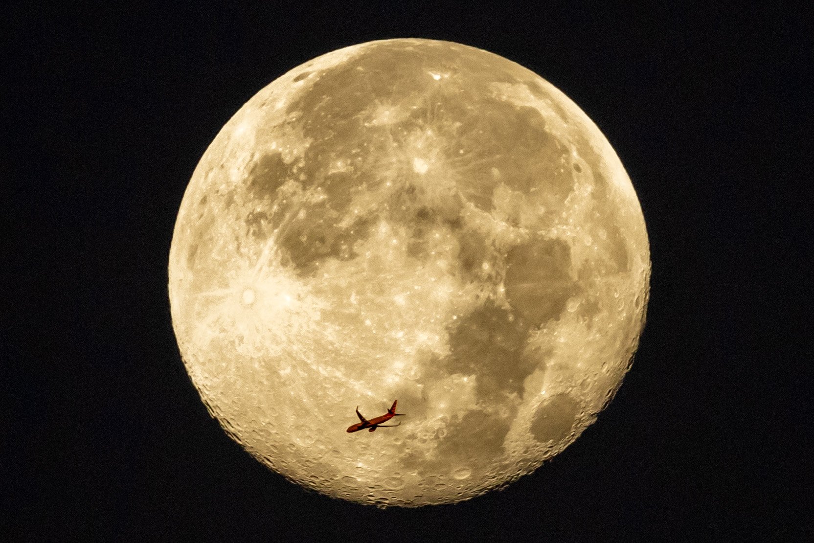 Plane flying past the moon before sunrise - October 30, 2023