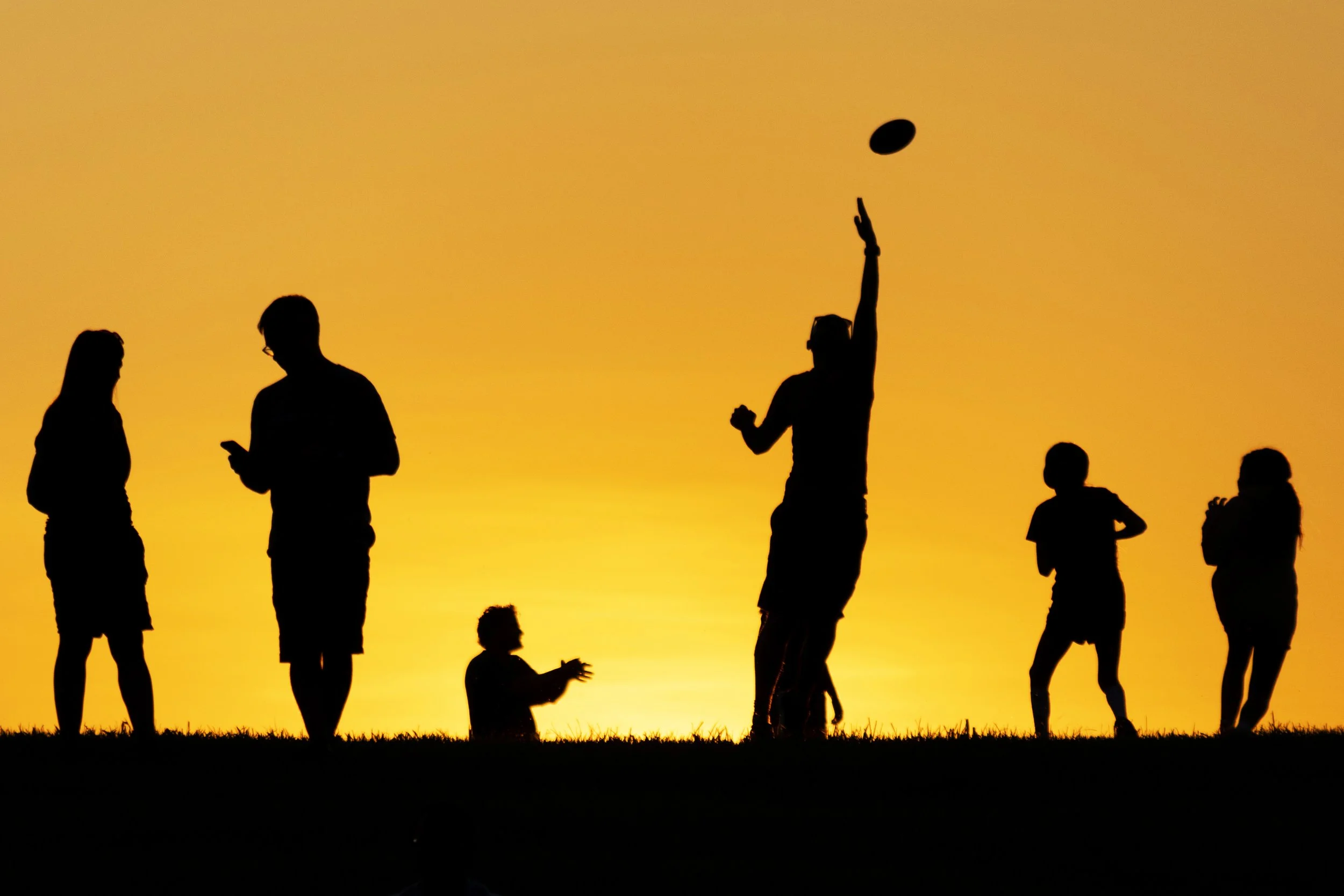 Silhouettes in the sunset at the Fort Reno summer concert - July 21, 2025