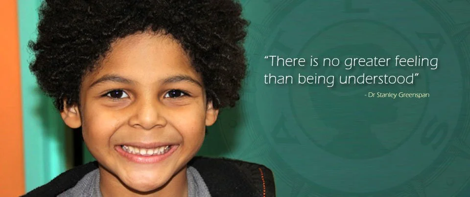 A young boy with curly hair smiling, with a quote about understanding written beside him.