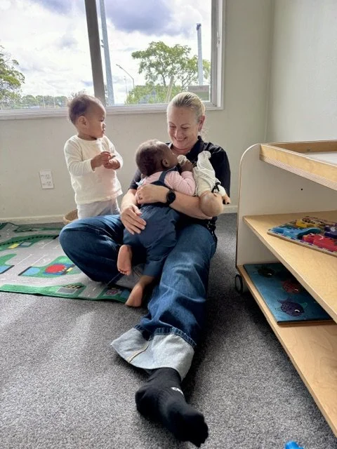 Teacher building secure, nurturing relationships with infants, supporting emotional wellbeing, trust and a strong sense of belonging.