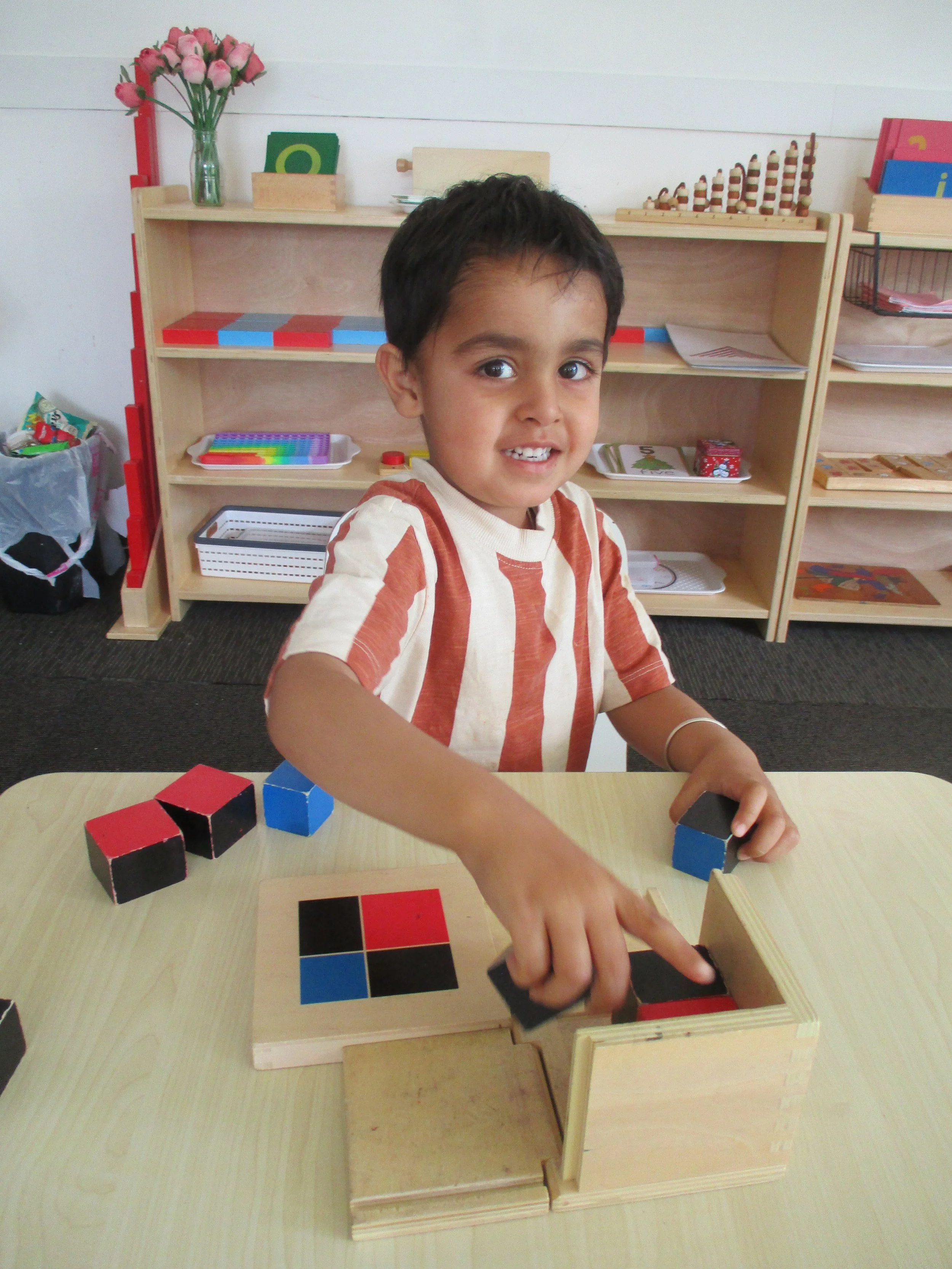 Child exploring Montessori-inspired learning materials, developing concentration, logical thinking and fine motor skills through independent play.