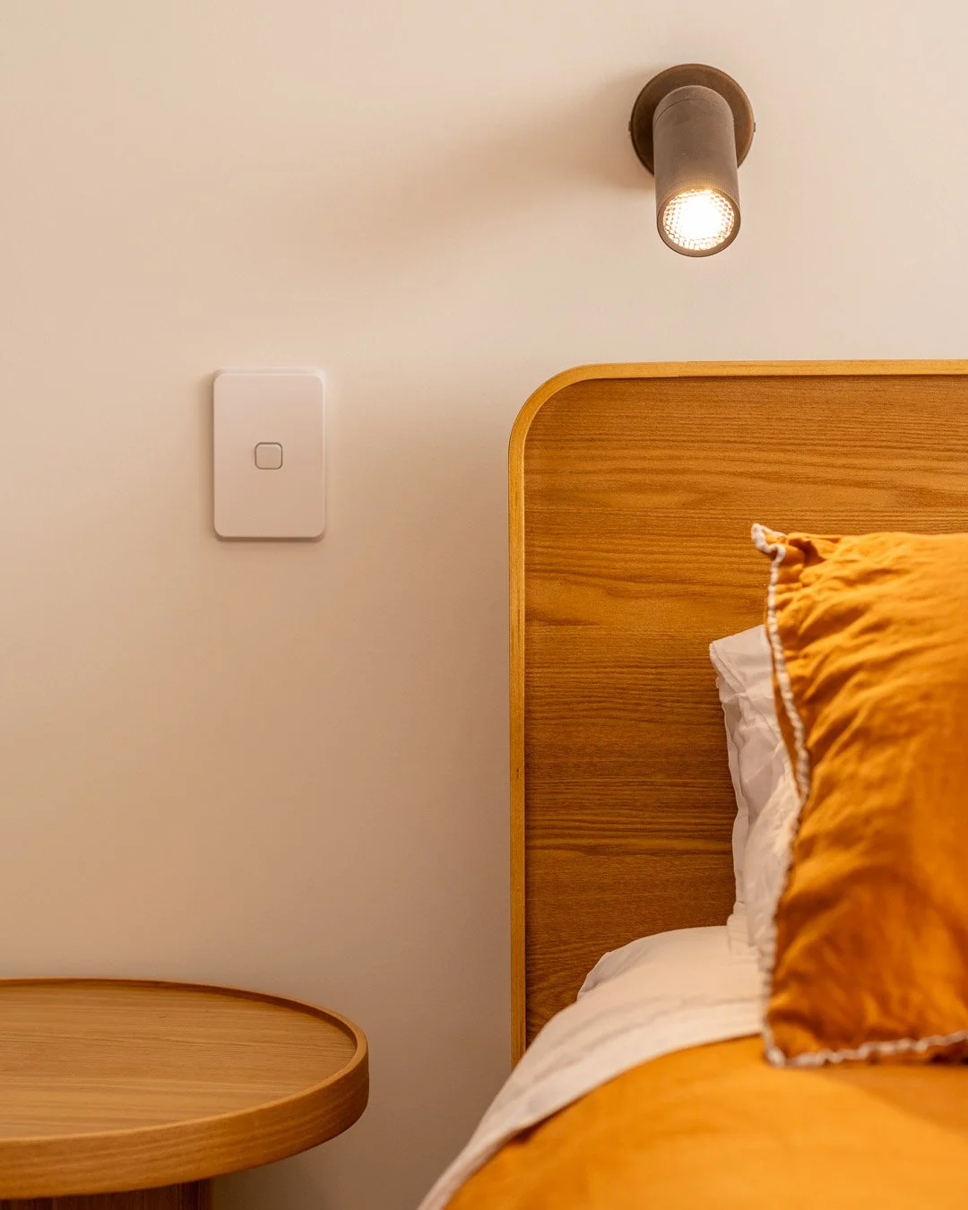 Quality light fittings and power points next to a designer bed setting