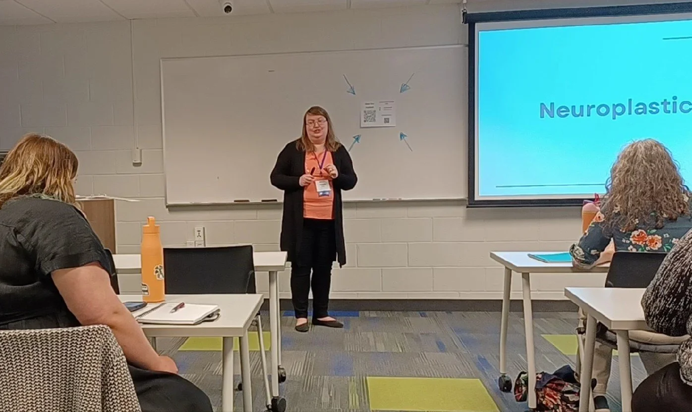 Michelle Pezley presenting at a conference talking about Neuroplasticity as part of confidence.'