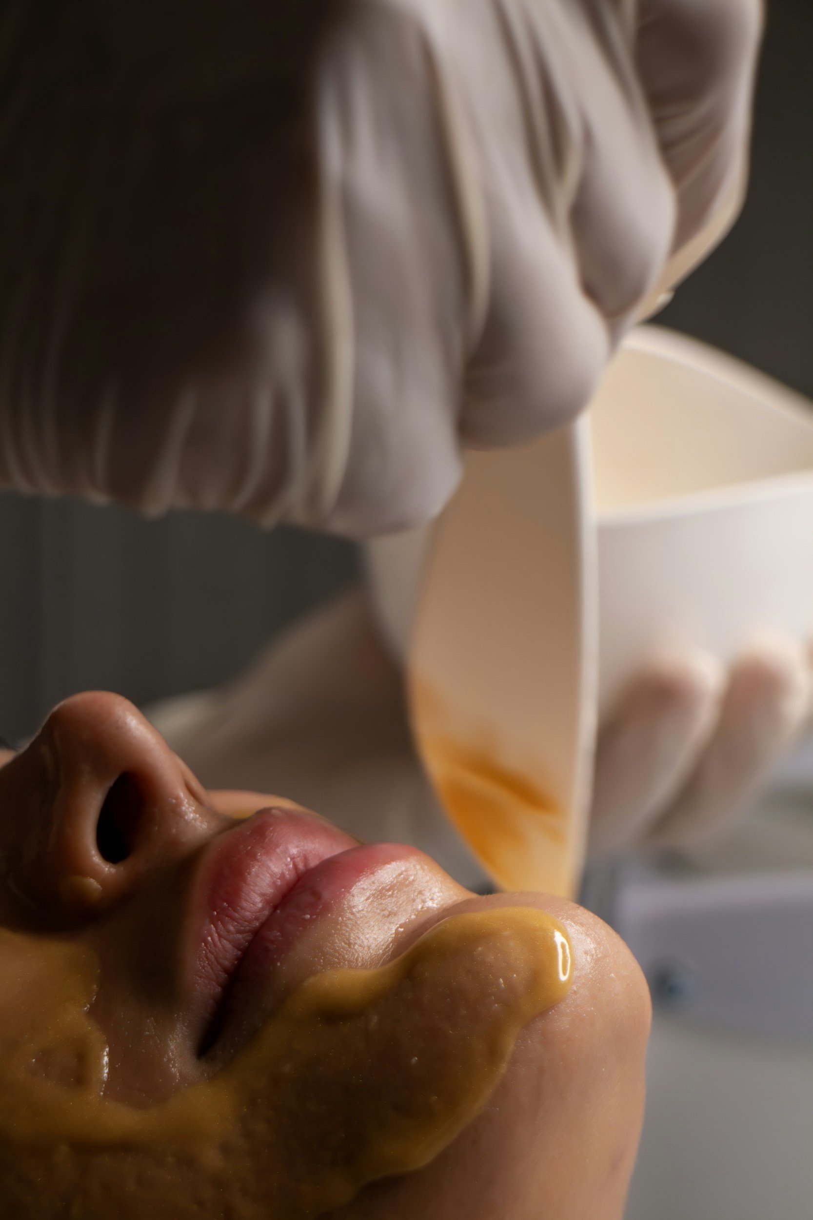 Close-up of a person applying wax to chin