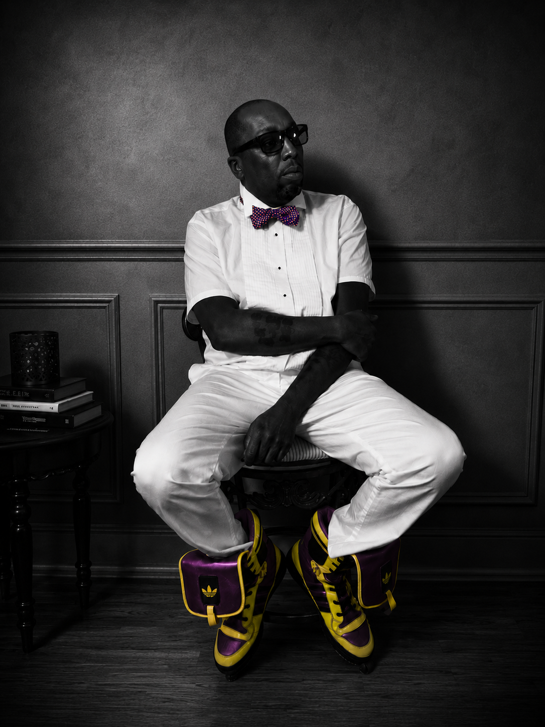 Marcus Watley seated in a formal black-and-white portrait, wearing glasses, a white shirt, and a bow tie.