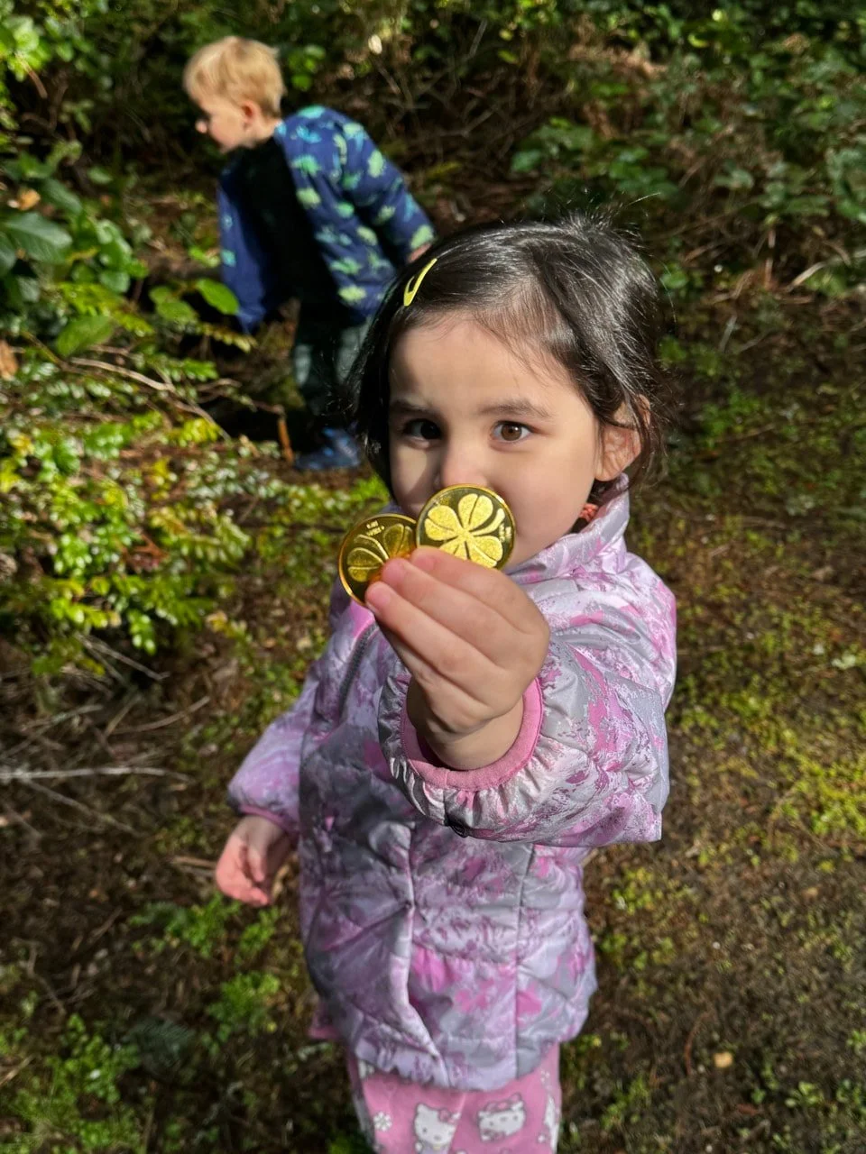 Child proudly showing treasures discovered during a nature exploration activity.