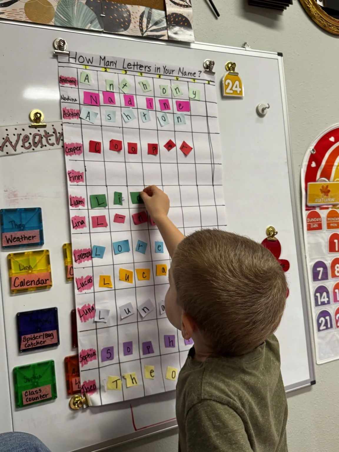 Child practicing numbers, letter recognition, and name building during a literacy activity.
