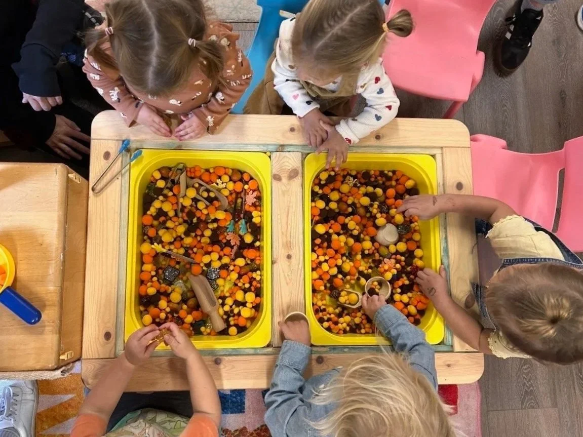 Children exploring a sensory table through hands-on play.