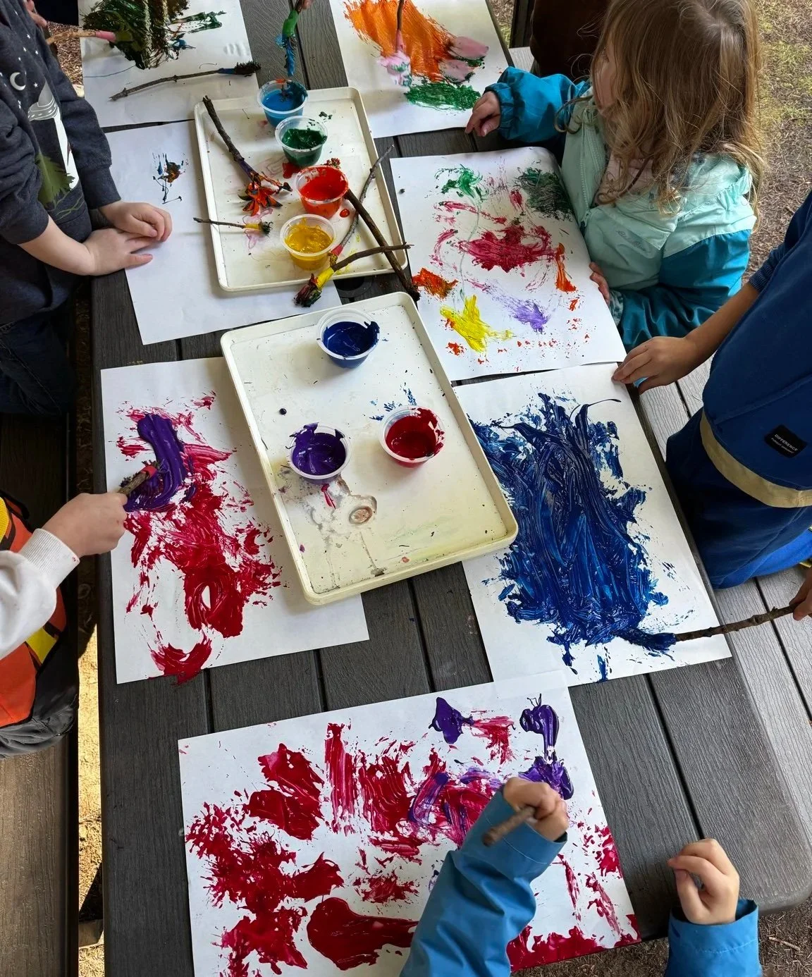 Children exploring creativity through process art using natural materials.