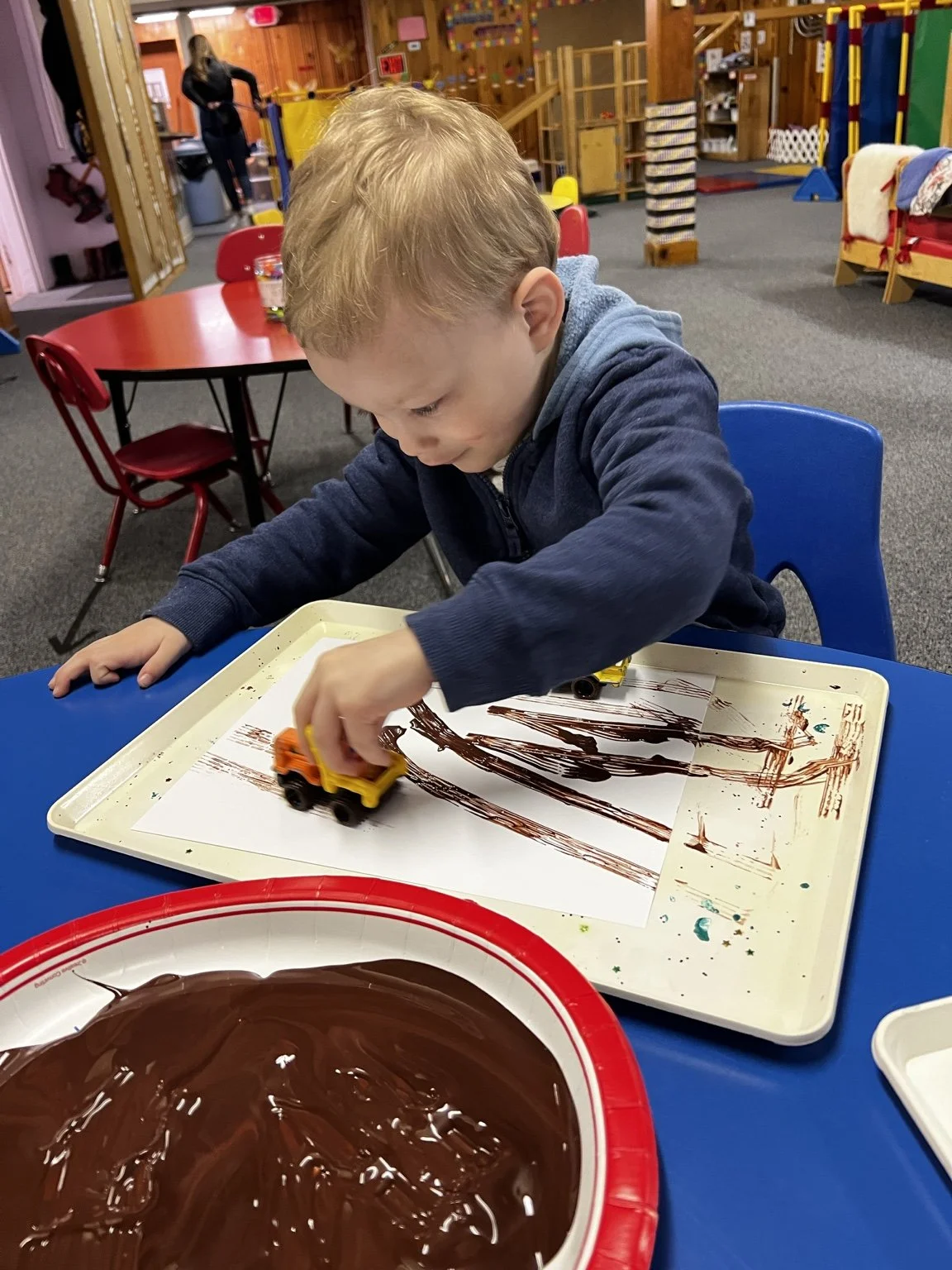 Child combining art and imaginative construction play.