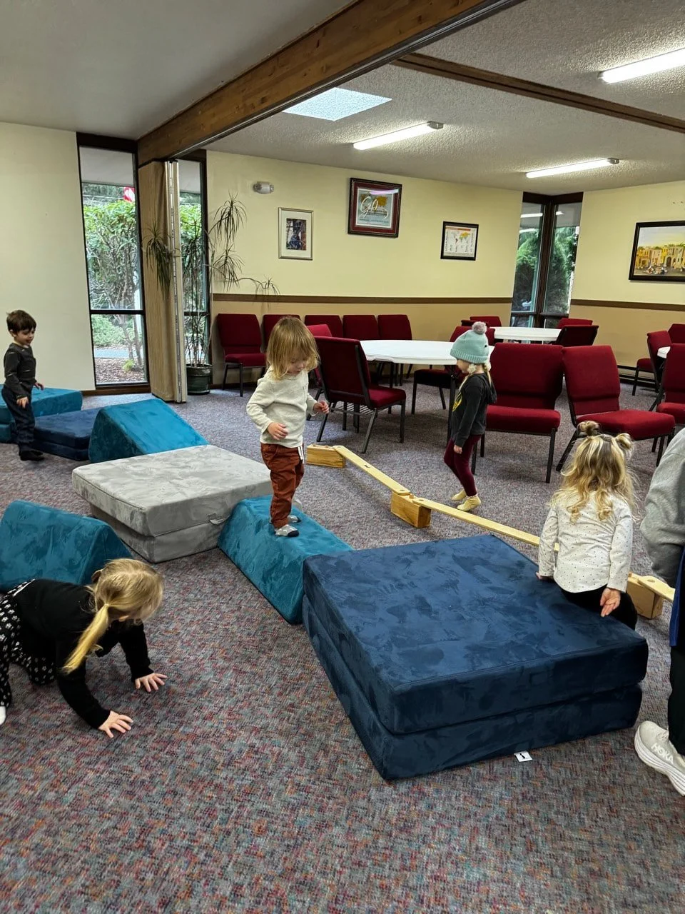 Children building balance and coordination through an indoor obstacle course.