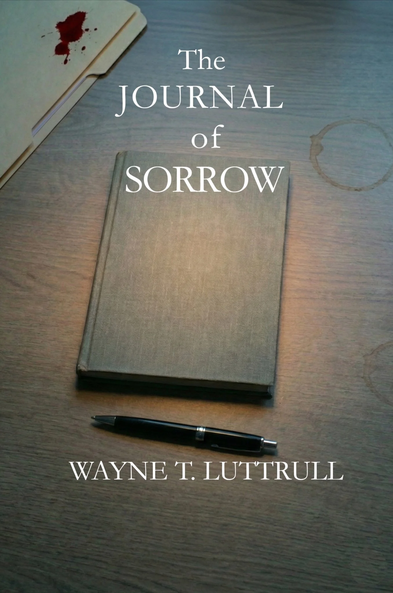 A closed book titled 'The Journal of Sorrow' on a wooden table. There is a black pen below the book and a faint coffee ring stain on the table. The author's name, Wayne T. Luttrull, is overlaid on the bottom of the image.