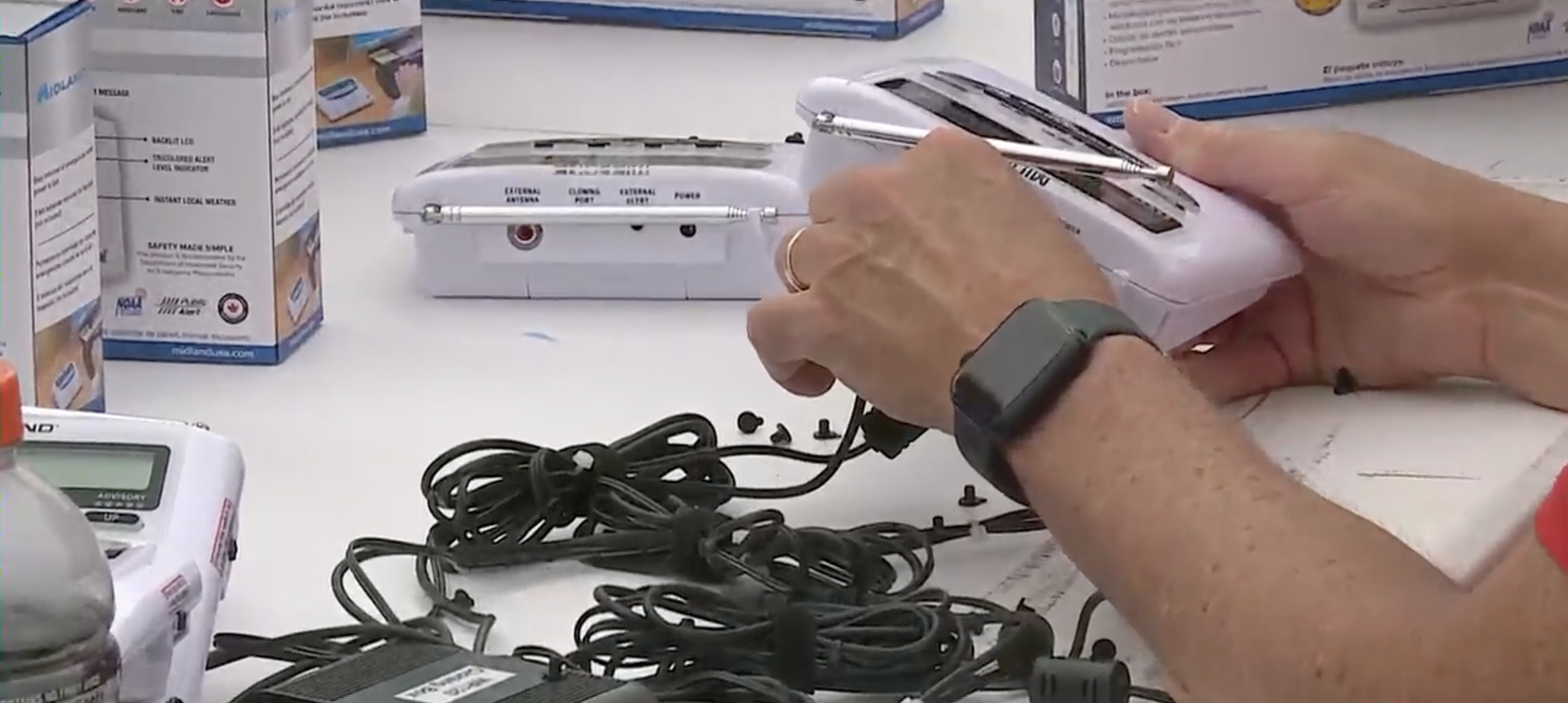 Close-up of a person's hands setting up a NOAA Weather Alert Radio