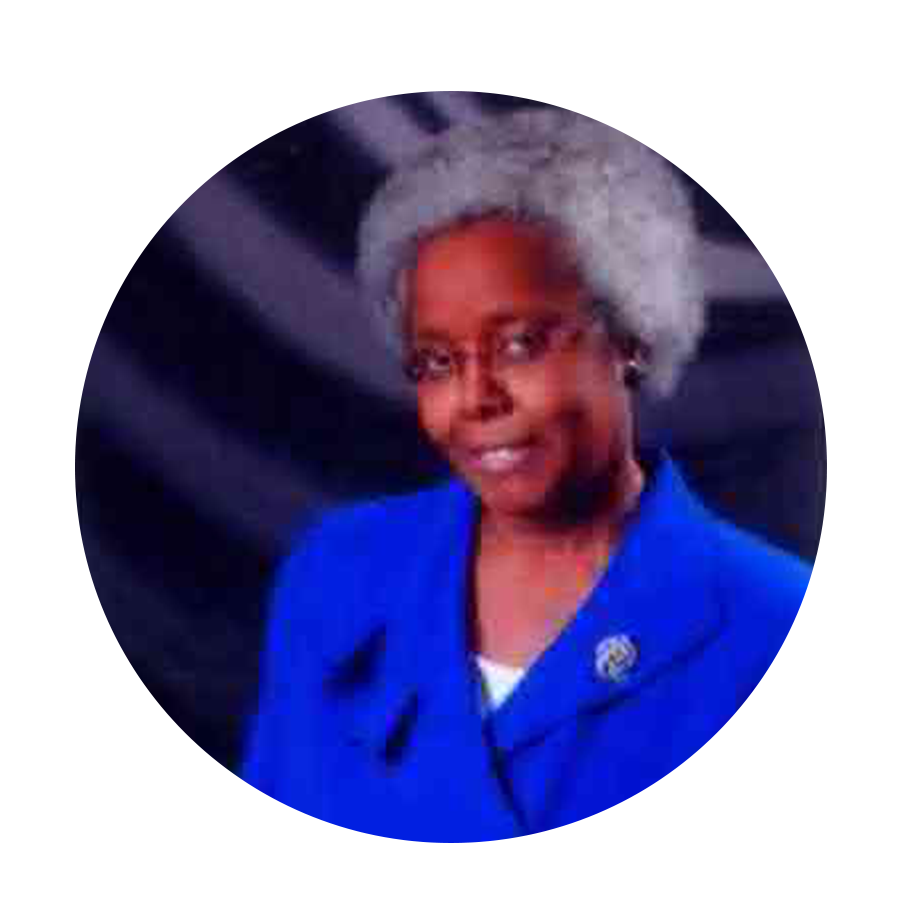 A woman with short gray hair, glasses, and a blue blazer smiling at the camera.